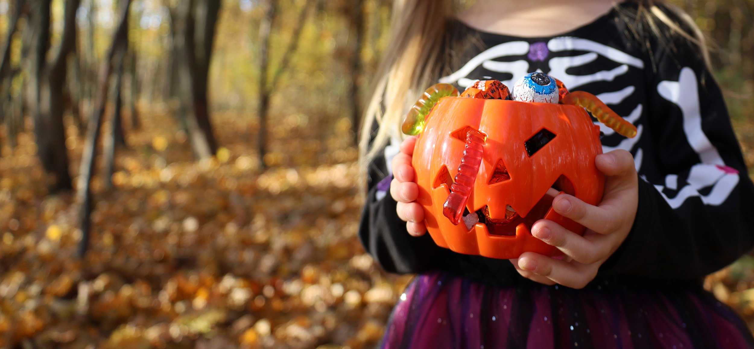 vecteezy_girl-dressed-skeleton-costume-holds-in-hands-orange-pumpkin_13629074.jpg