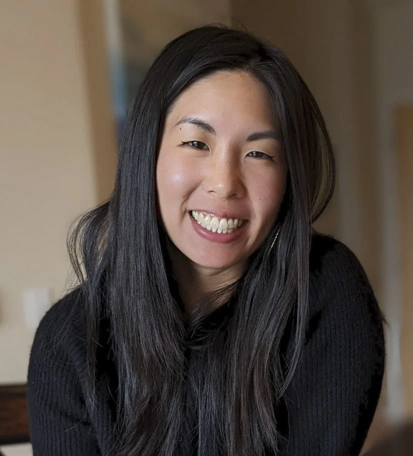 Katie Chen is smiling against a neutral background, wearing a black shirt.