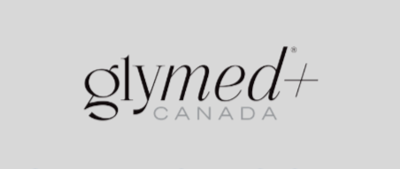 Black and white photo of a person receiving a cosmetic or medical treatment, with a practitioner holding a small tool near their face, which appears to have a substance applied on it, in an environment with various containers in the background.