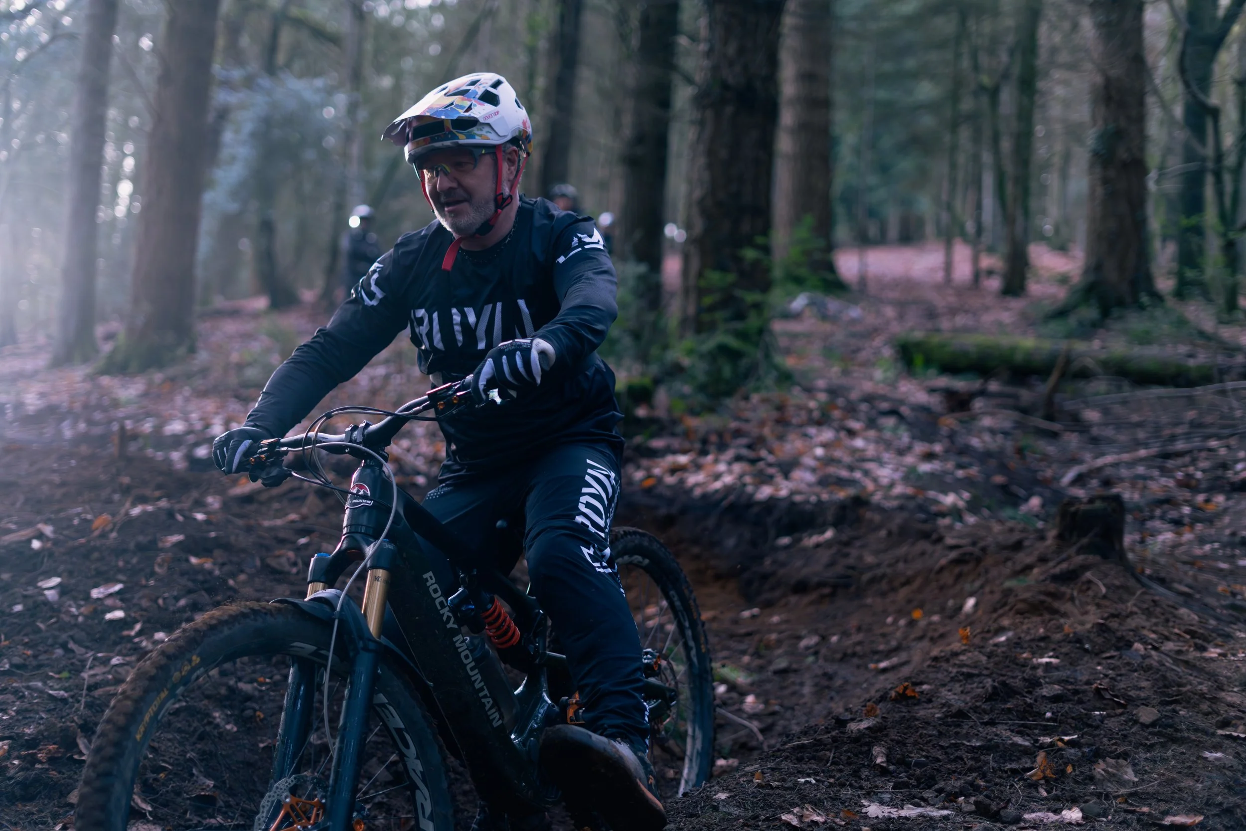 A man riding a mountain bike through a forest trail during daytime.