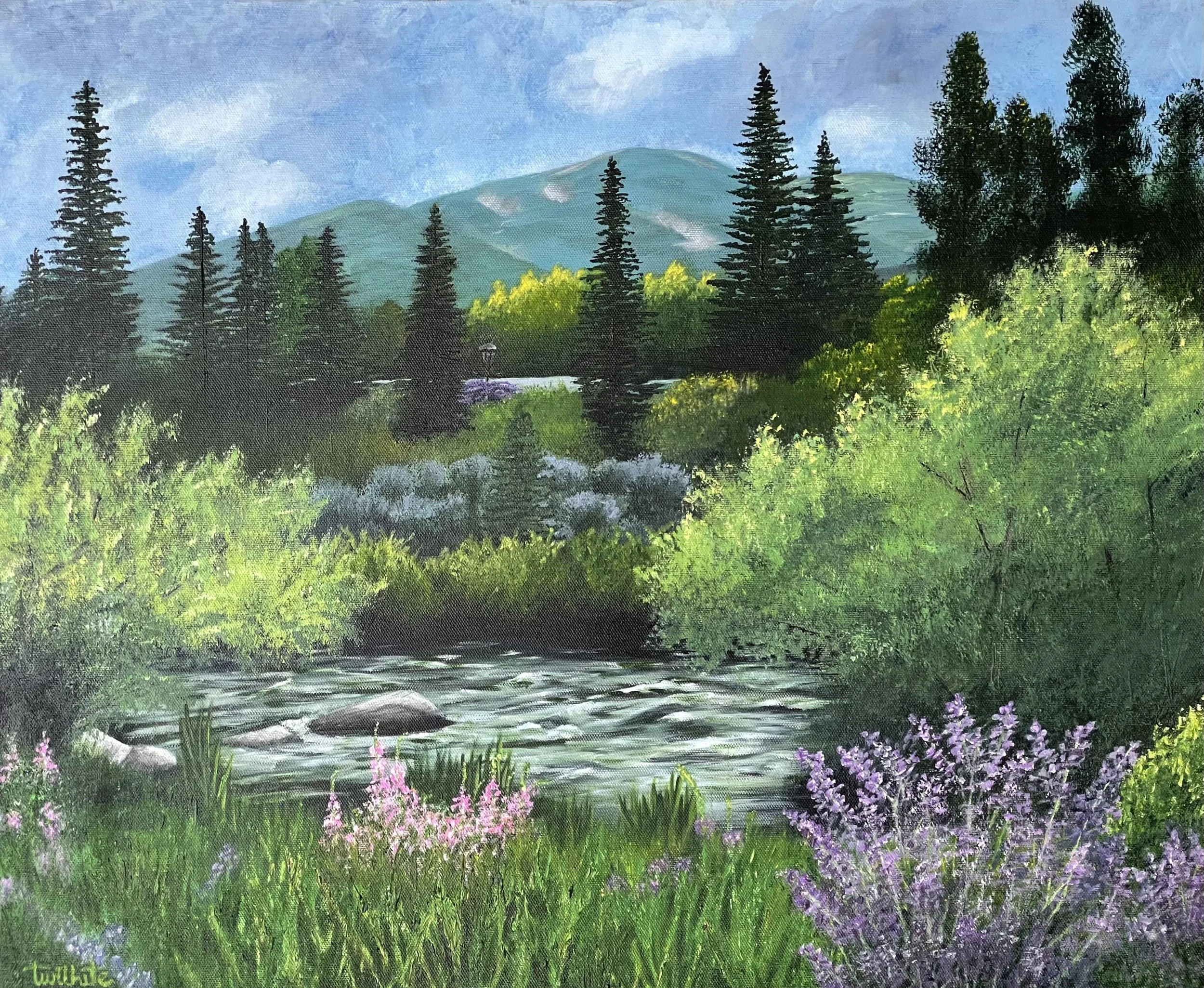 Landscape painting of a lush green forest with a river in the foreground, pink and purple flowers along the banks, evergreen trees, and mountains in the background under a cloudy blue sky by artist Tanya Wilhite