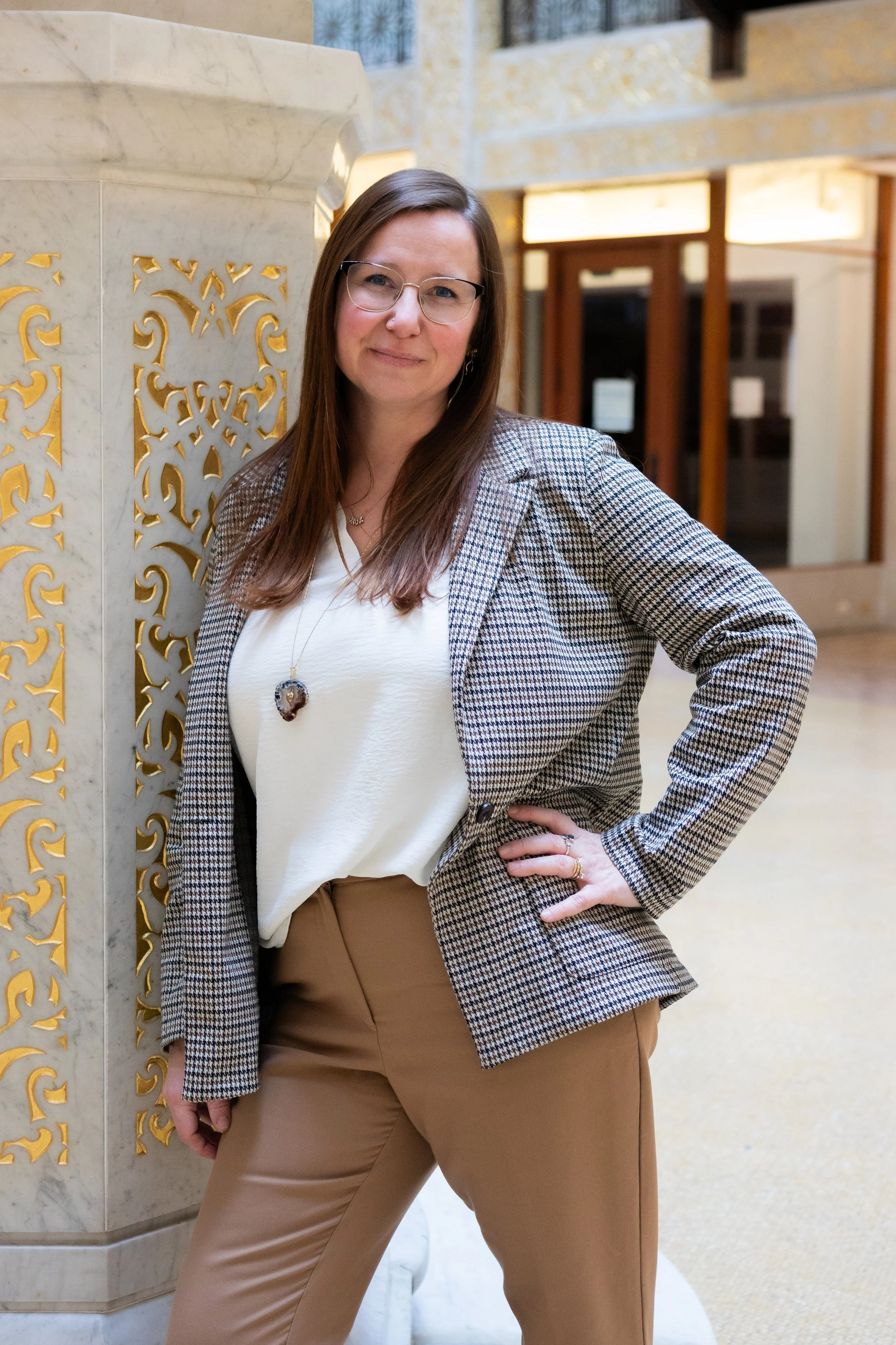 Jaime Lawrence, a woman with wavy blonde hair smiling and standing in front of a colorful graffiti wall (Bright Walls downtown Jackson, MI)