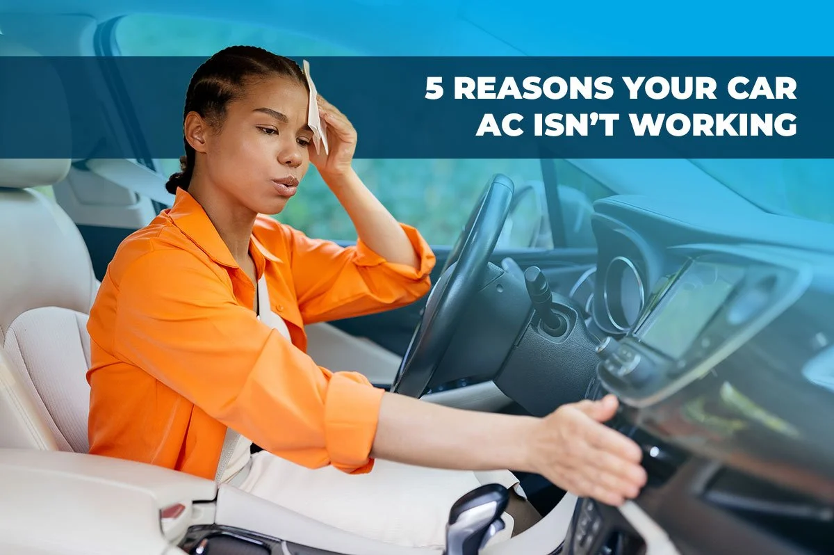 Woman in the driver's seat of a car wiping her brow and checking the air vents