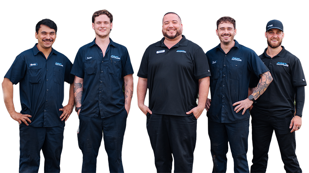 Five men wearing matching blue shirts with logos, standing together and smiling for a photo.