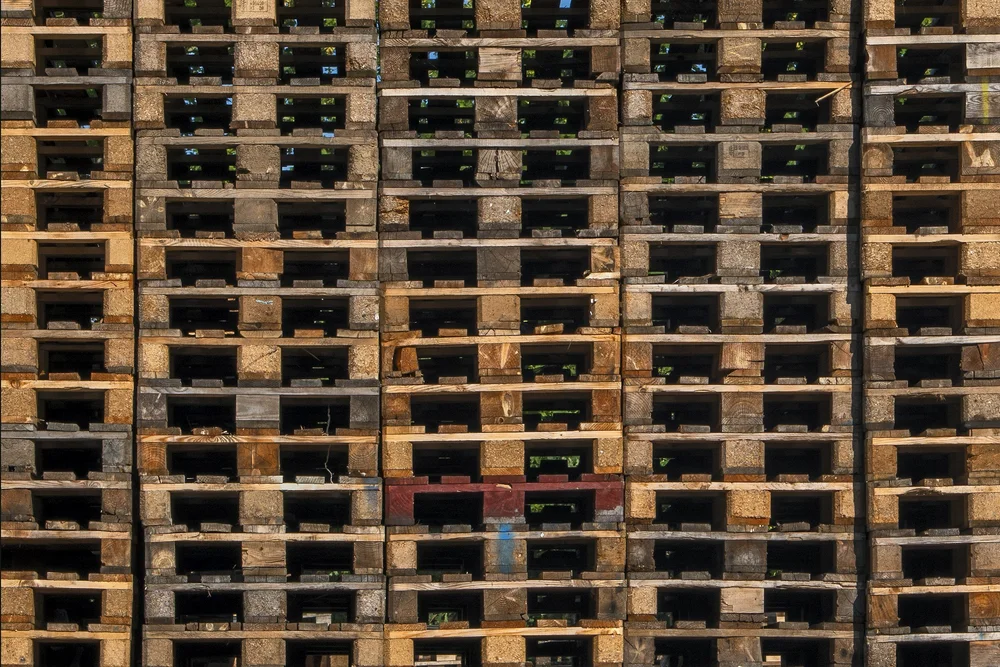 Stacks of recycled 48x40 wooden pallets.