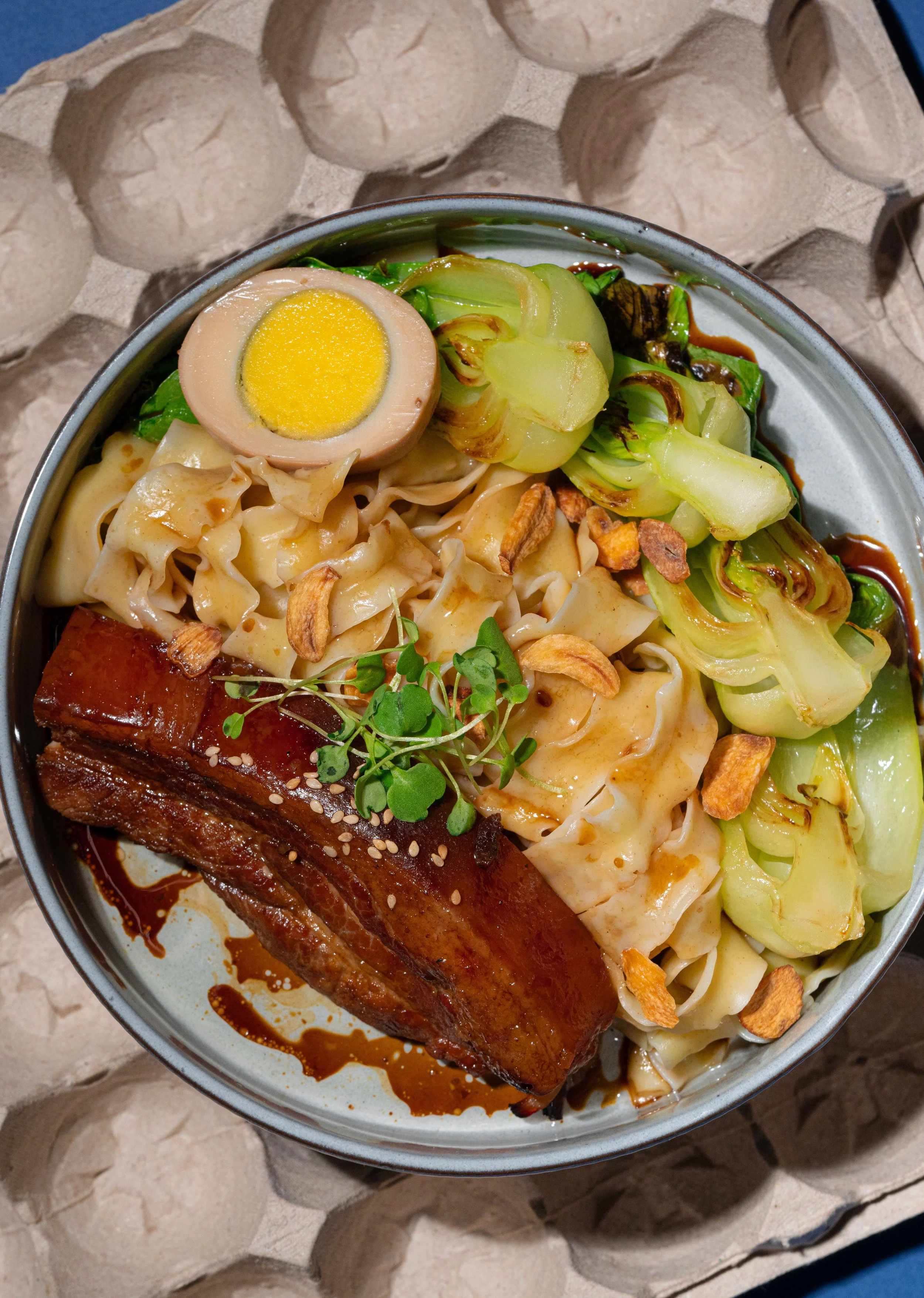 Pongteh pork noodle, a signature dish at Nounou Noodle Bar in New York, featuring braised pork in fermented soybean sauce with noodles.