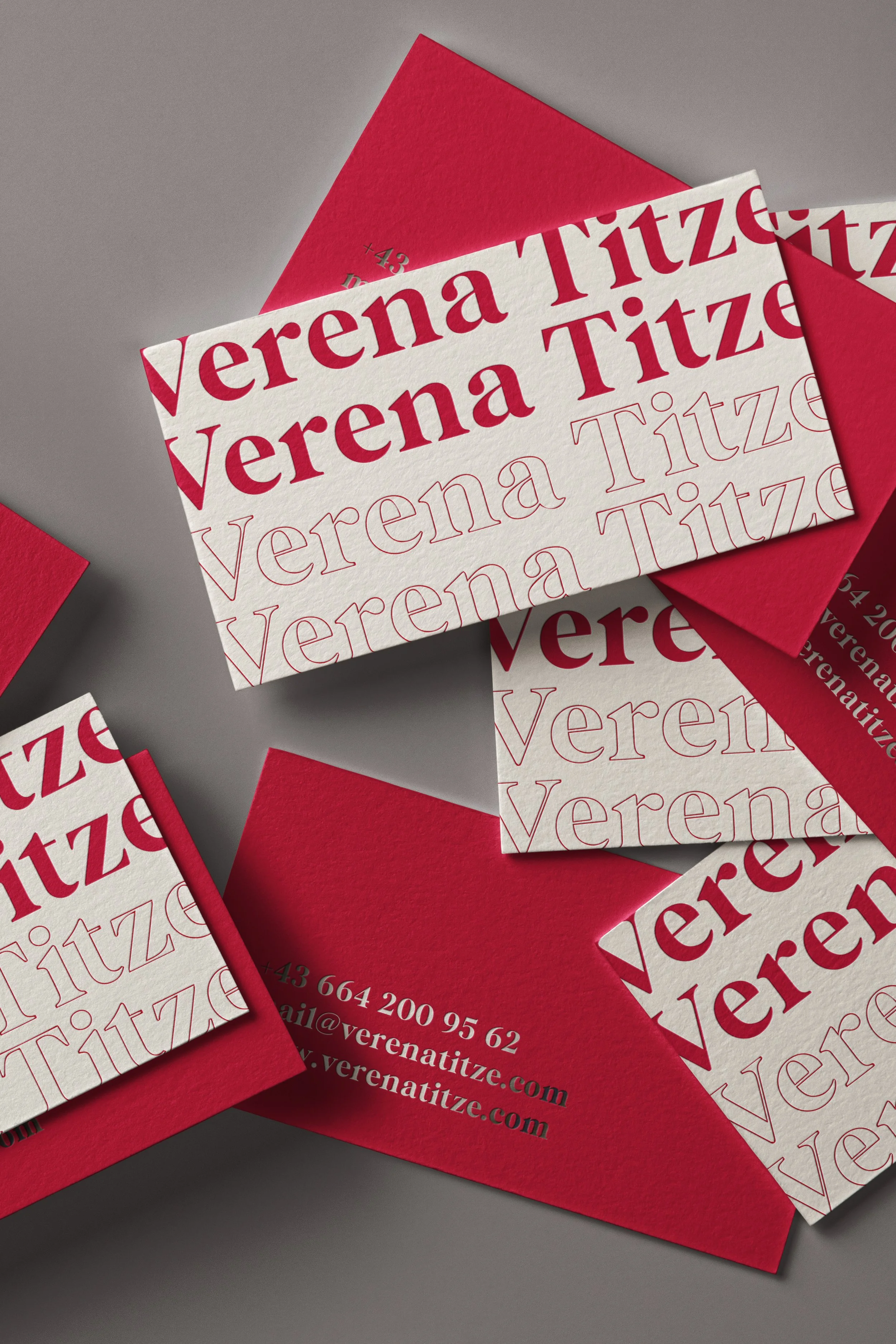 Visitenkarten und Umschläge in Rot und Weiß mit dem Namen 'Verena Titz' und Kontaktdaten.