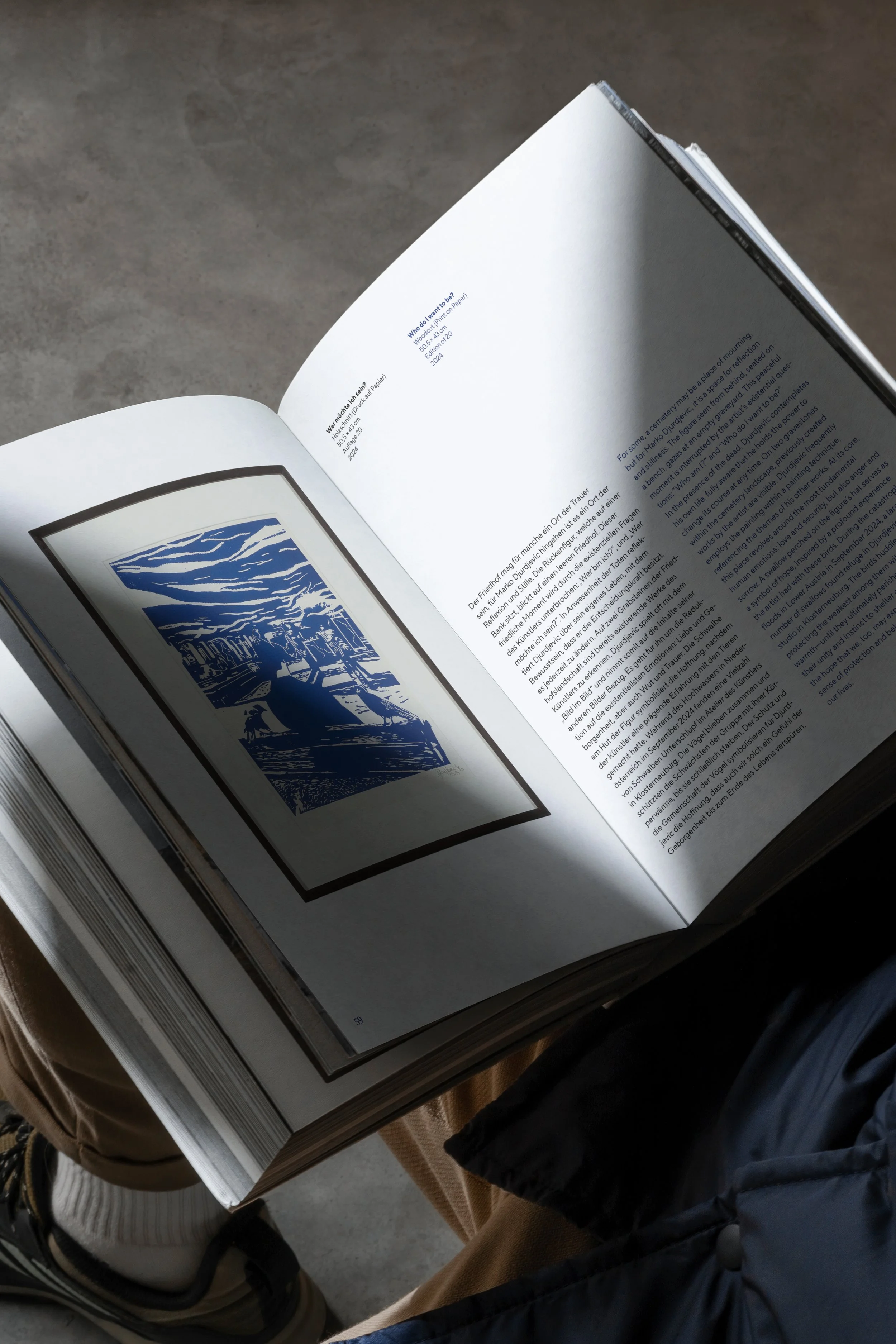 Offenes Buch mit Bild einer Holzschnitt-ähnlichen Landschaft auf der linken Seite und Text in englischer und deutscher Sprache auf der rechten Seite.