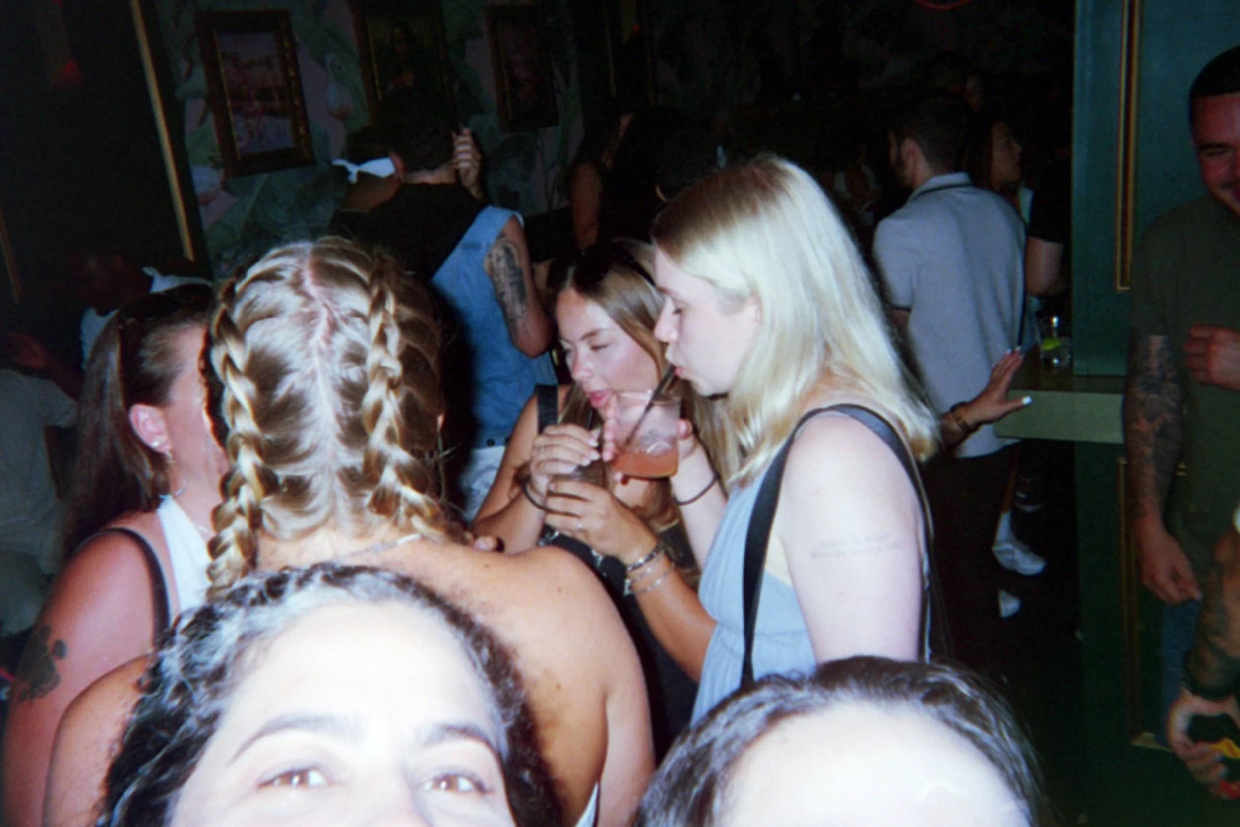 Group of women having drinks at a crowded party or club.