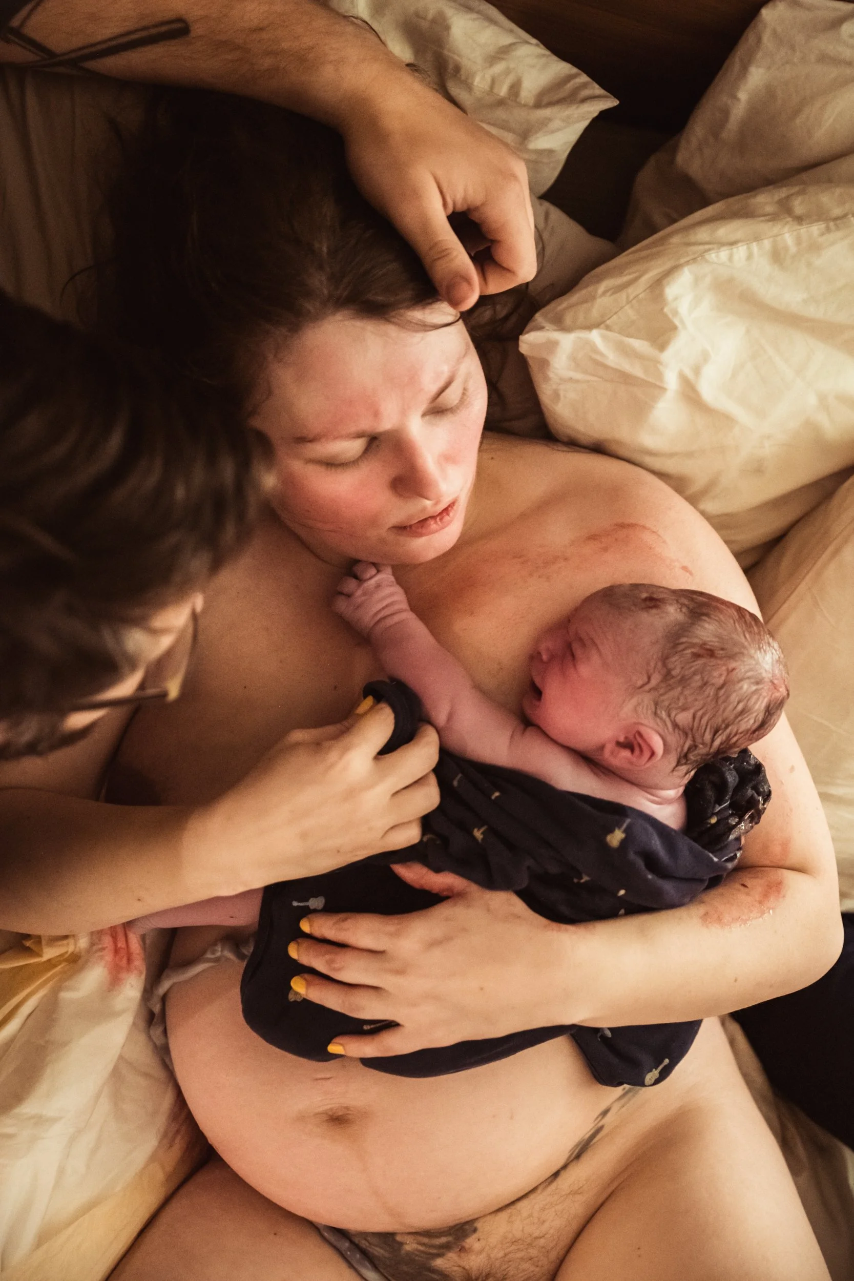 Woman_holding_newborn_right_after-giving_birth_at_home_held_by_her_husband_photograph_courtesy_of_Los_Angeles_birth_photographer_dear_birth