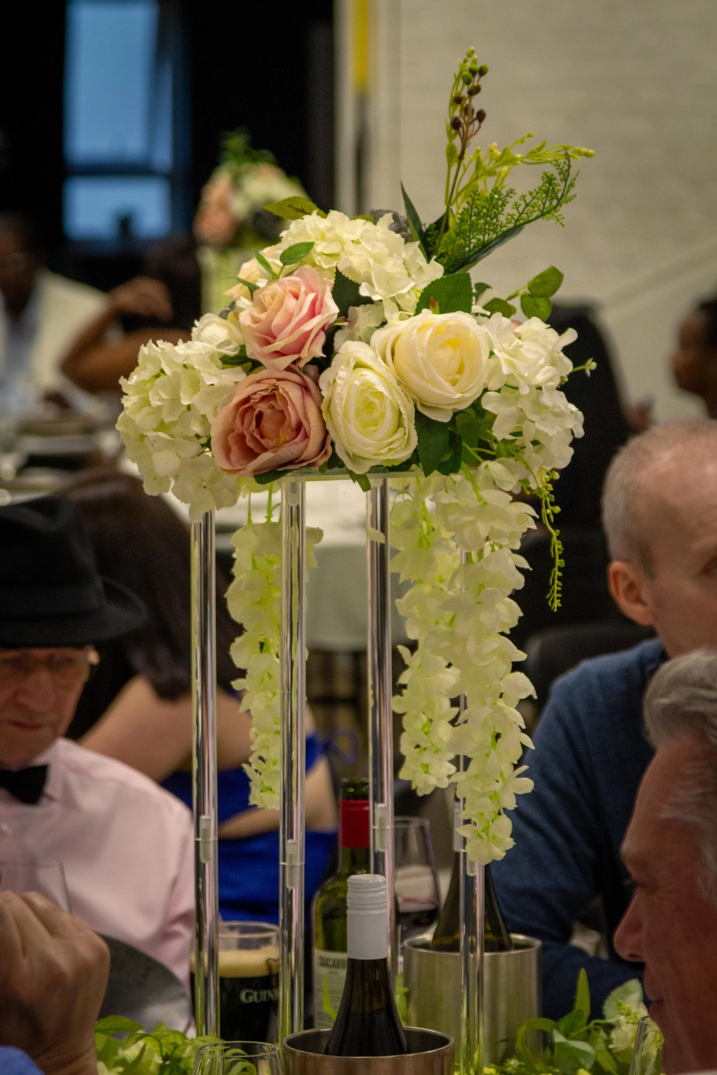 Artificial floral arrangements with white and gold flowers placed on a kitchen countertop.