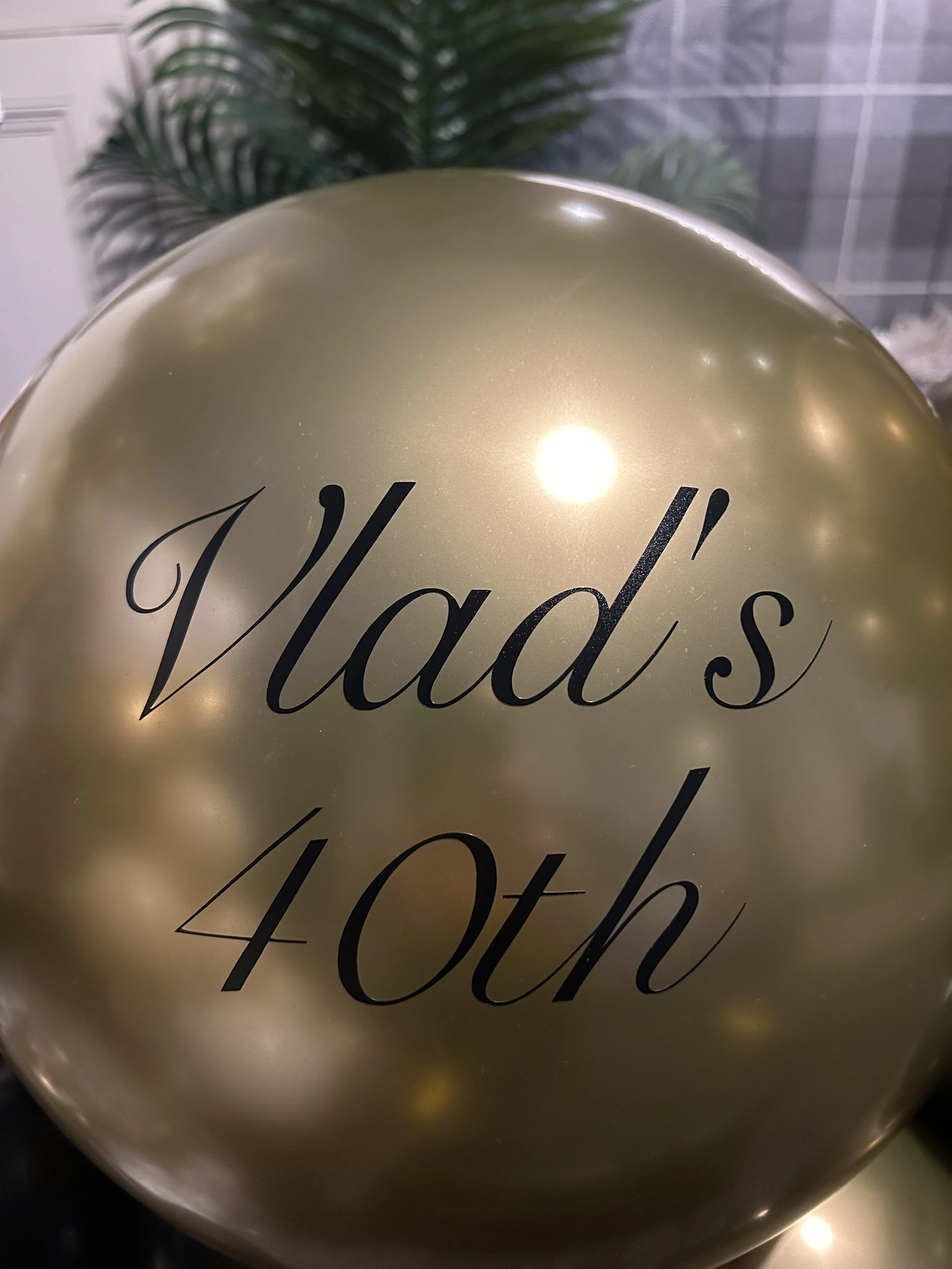 Gold balloon with black text that reads "Vlad's 40th"