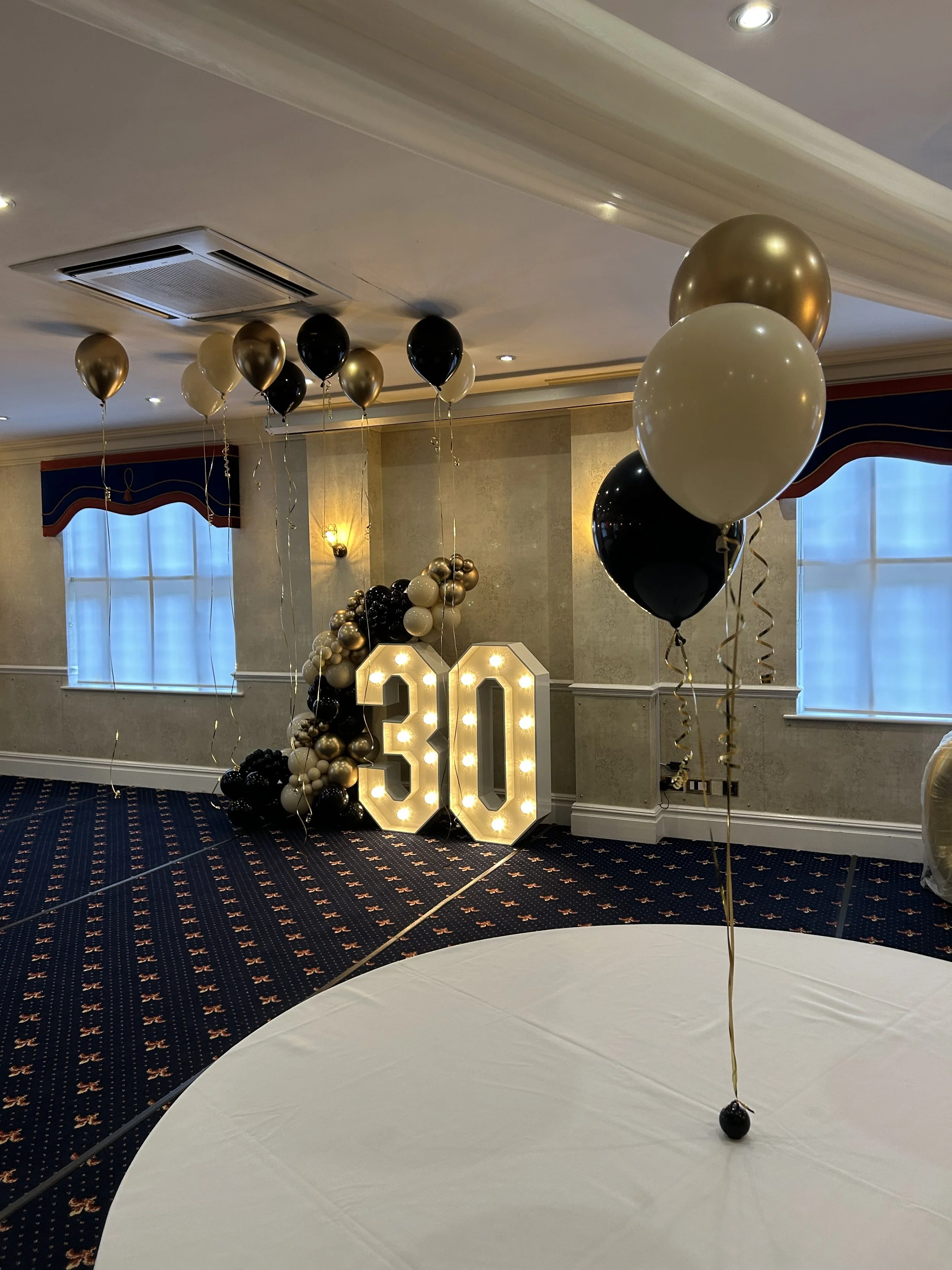 Decorations for a 30th birthday celebration including illuminated 