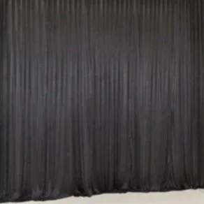 A black curtain hanging with vertical pleats.