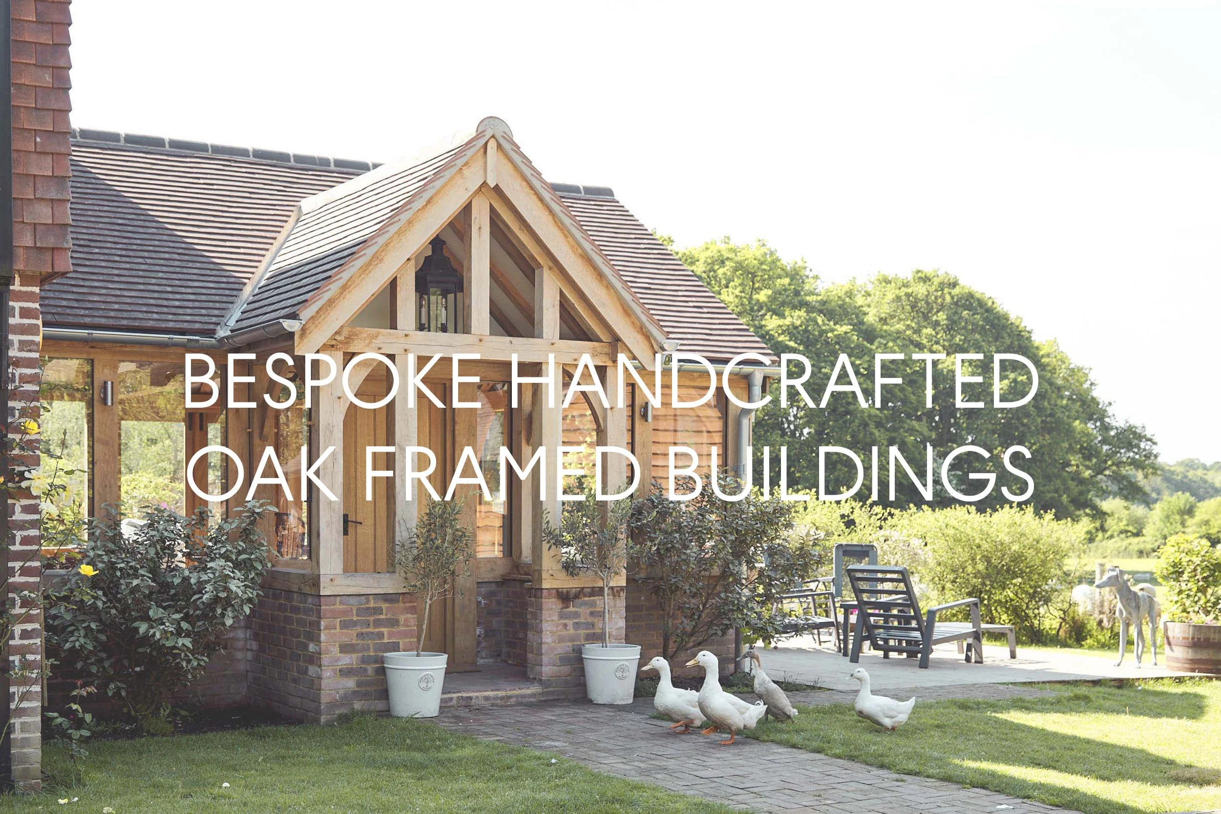 An oak framed porch entrance into an oak frame extension, with glazed panels, and rural gardens, with ducks walking past.