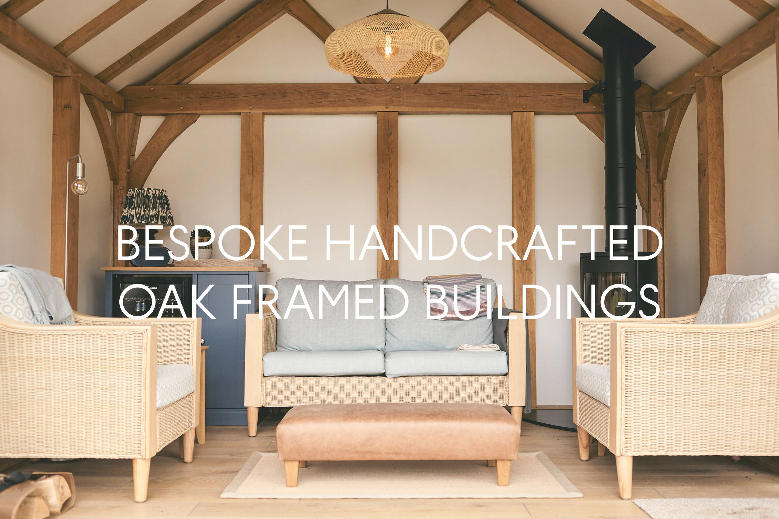 Living room with oak timber frame walls, beige and wicker furniture, a blue cabinet, a woven light fixture, and a black wood stove.