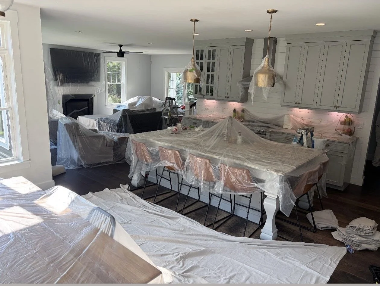 Interior painting preparation with furniture and kitchen protected