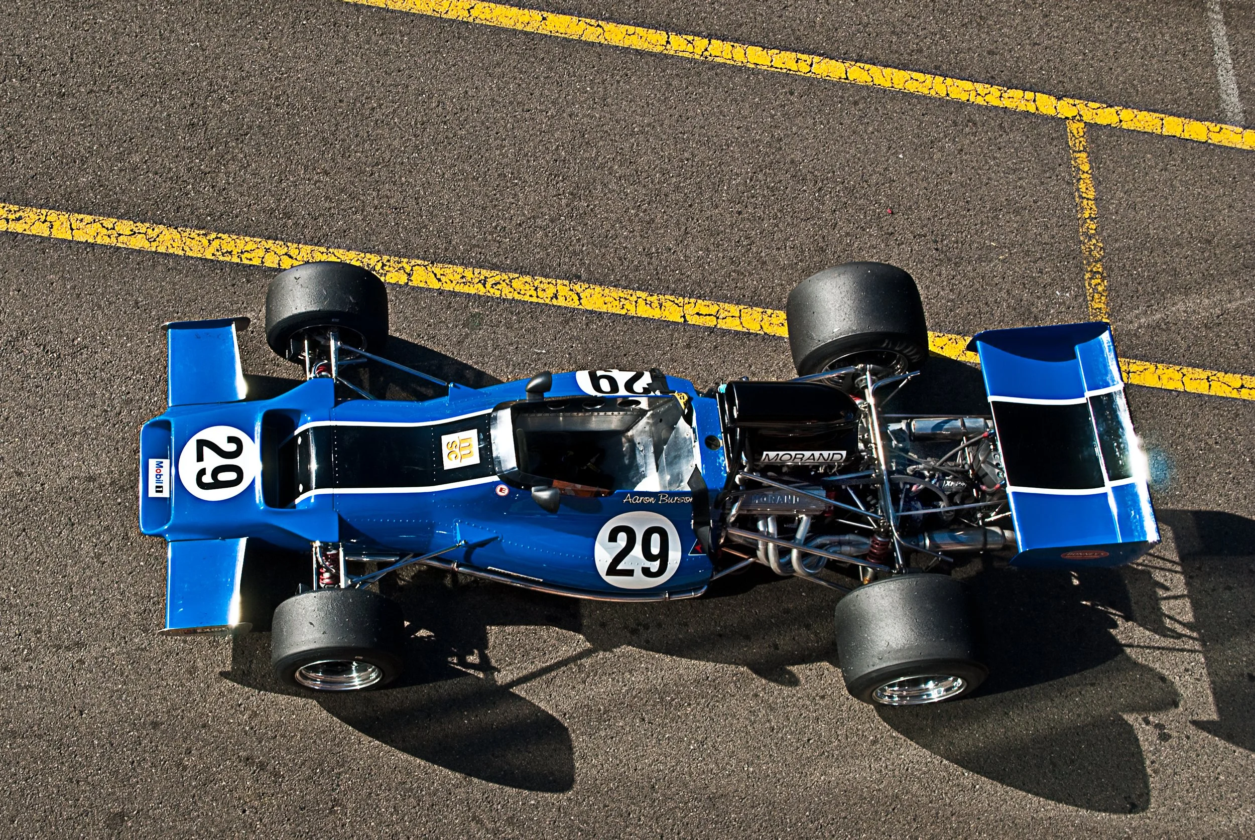 Top-down view of a Formula 5000 open-wheel race car, parked outside the pit garage.