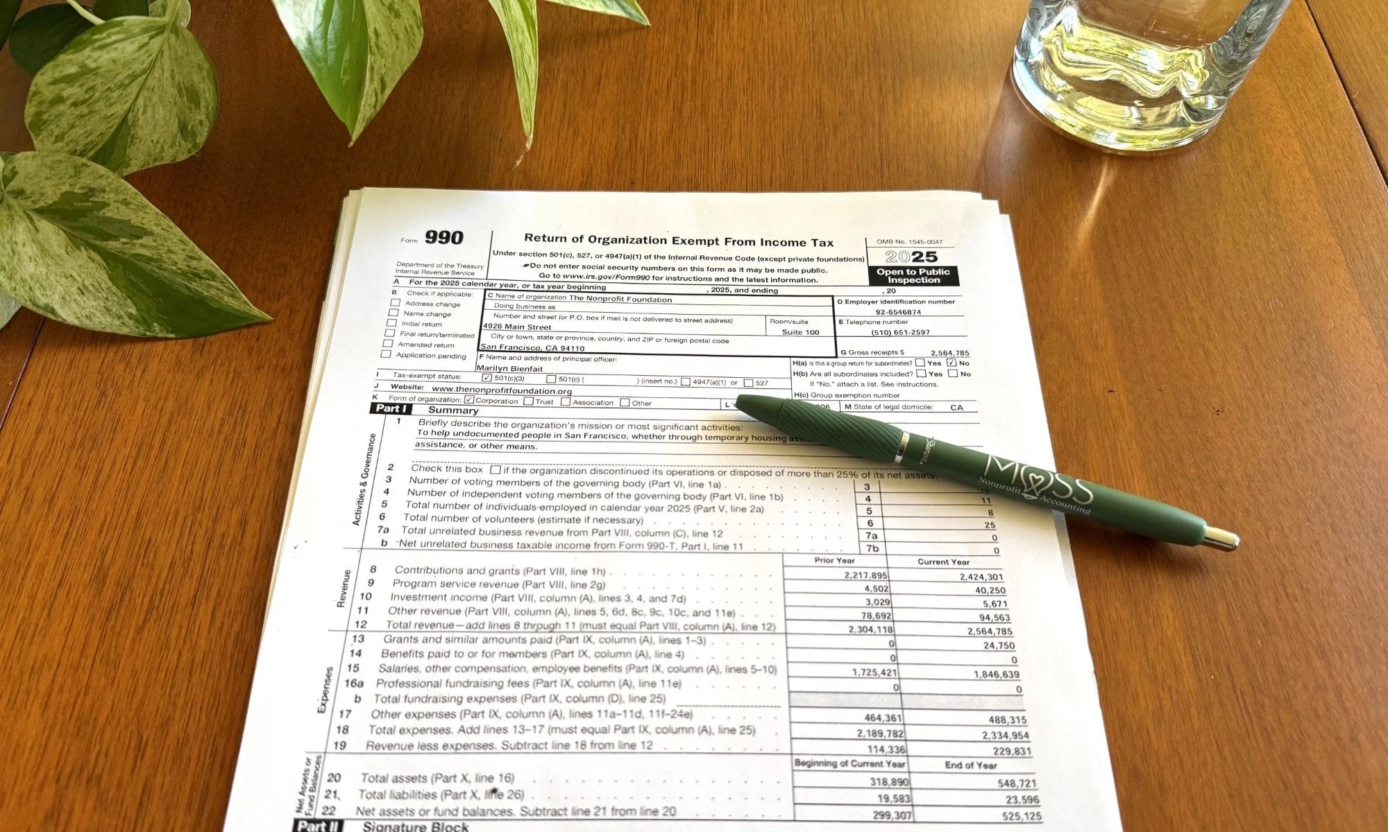 A nonprofit's 990 being reviewed on a desk with a green pen from Moss Nonprofit Accounting