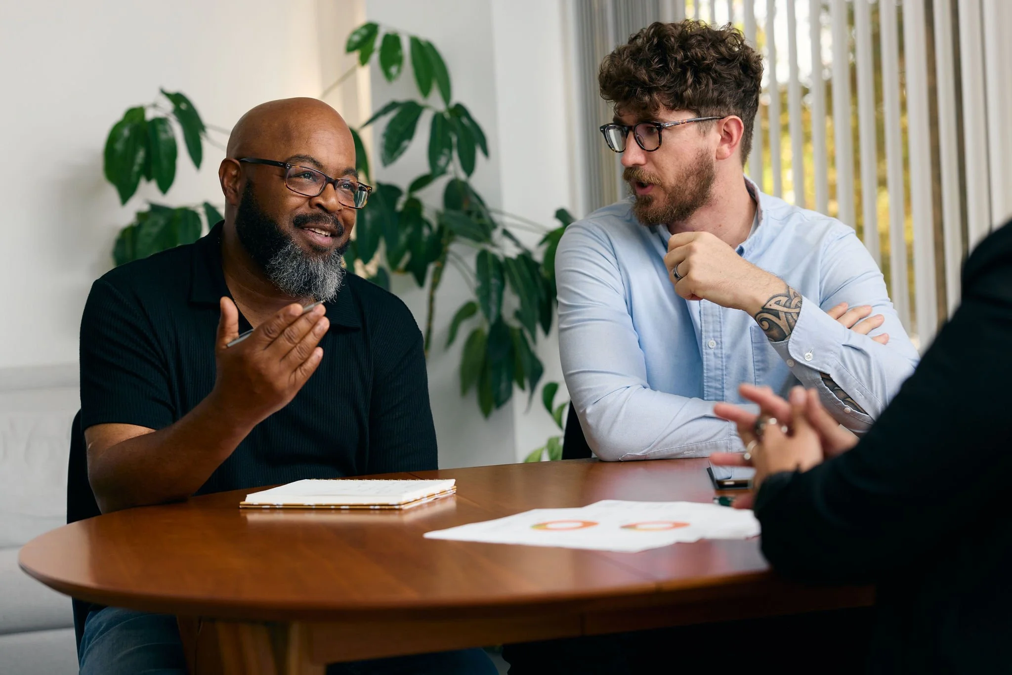 Team members from Moss Nonprofit Accounting meeting in their Walnut Creek office, with large windows and green plants in the background