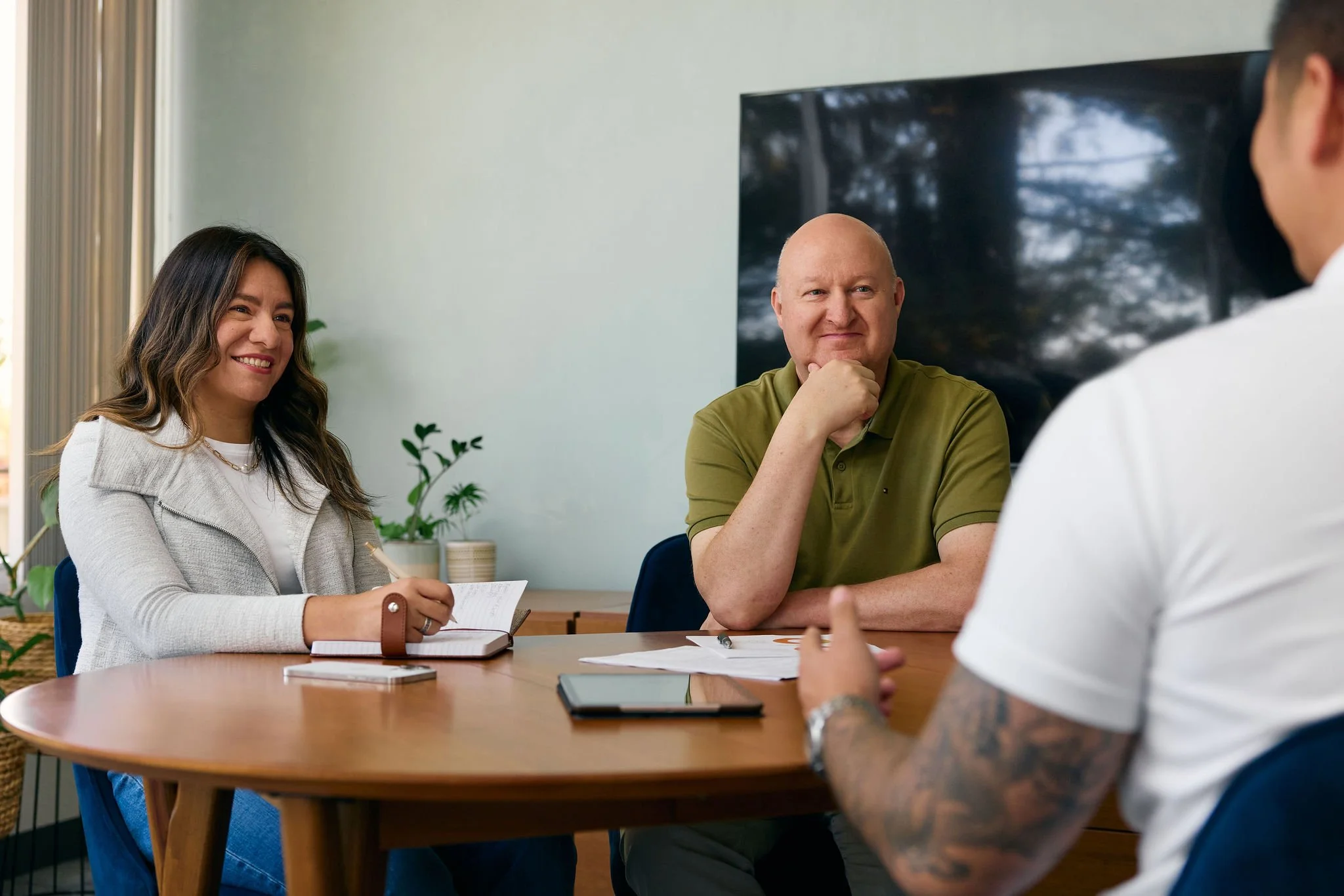 A relaxed client consultation with the Moss Nonprofit Accounting team in a sunlit office with plants.