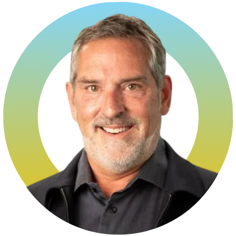 A man with short hair, a beard, and a friendly smile, wearing a dark collared shirt and jacket. Background featuring a gradient circle with shades of blue, green, yellow, and purple.