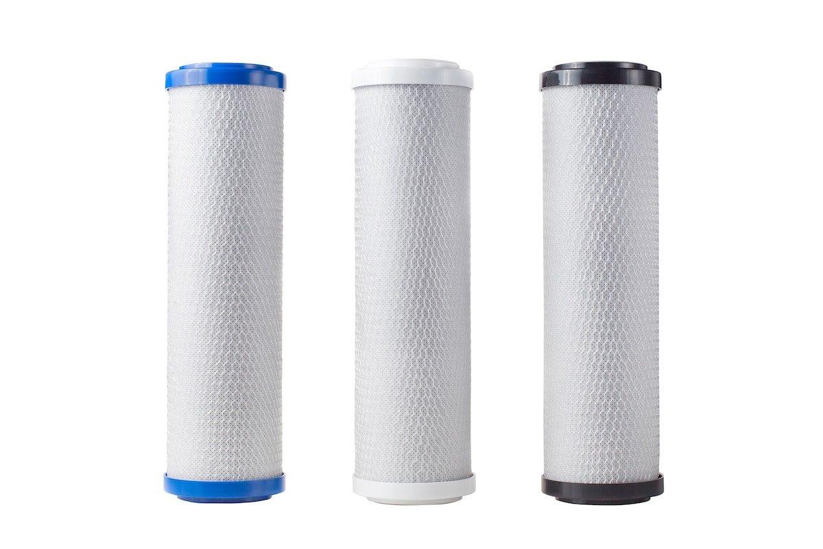 Three cylindrical water filter cartridges with blue, white, and black tops, aligned side by side on a white background.