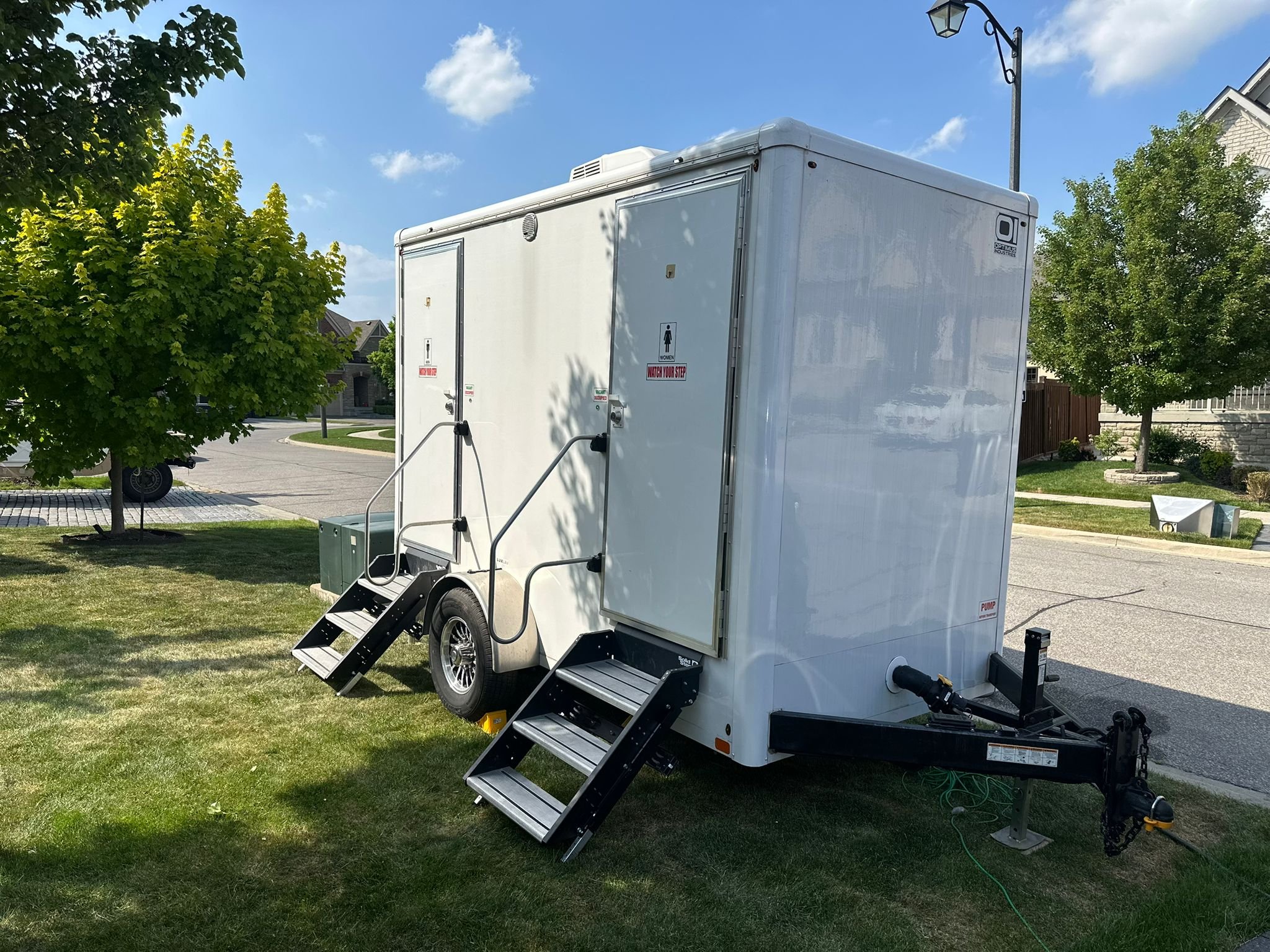 A white 2-unit washroom trailer parked outside.