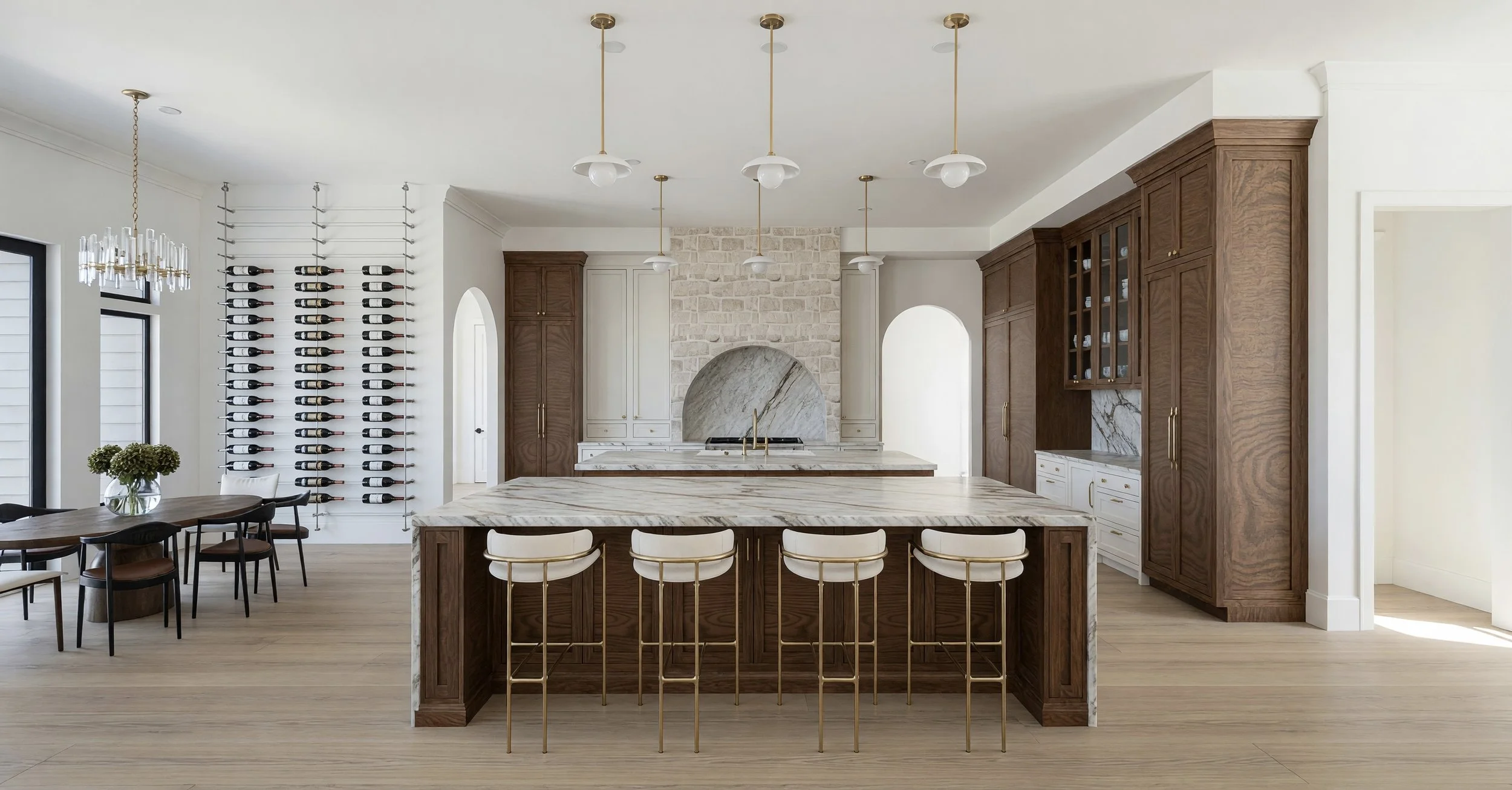 Modern kitchen with a marble island, wooden cabinets, a wine rack on the wall, and pendant lighting fixtures.
