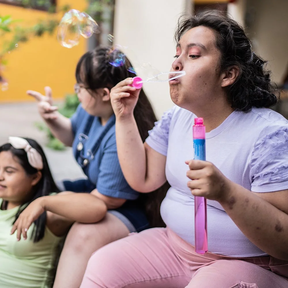 Hispanic woman with special needs blowing bubbles
