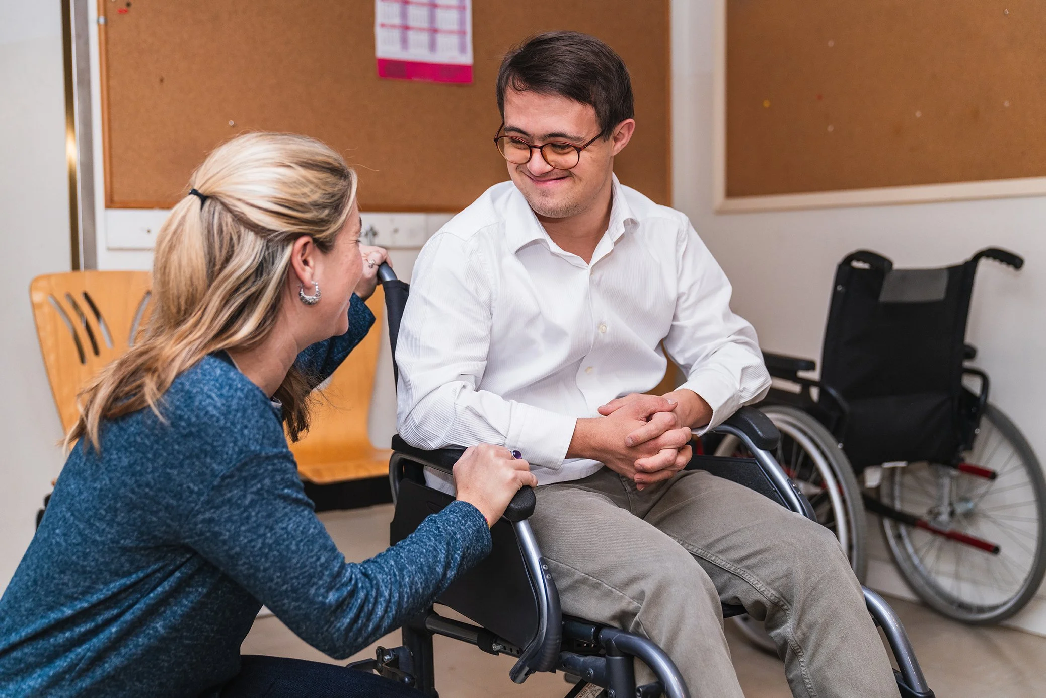 Woman and special needs man in wheelchair talking