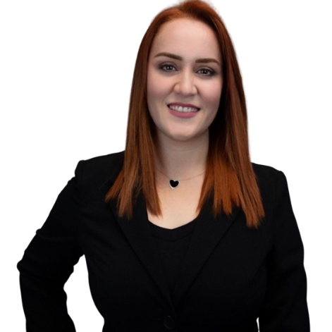 Mujer con cabello rojo, sonriendo, usando chaqueta negra y collar de corazón negro