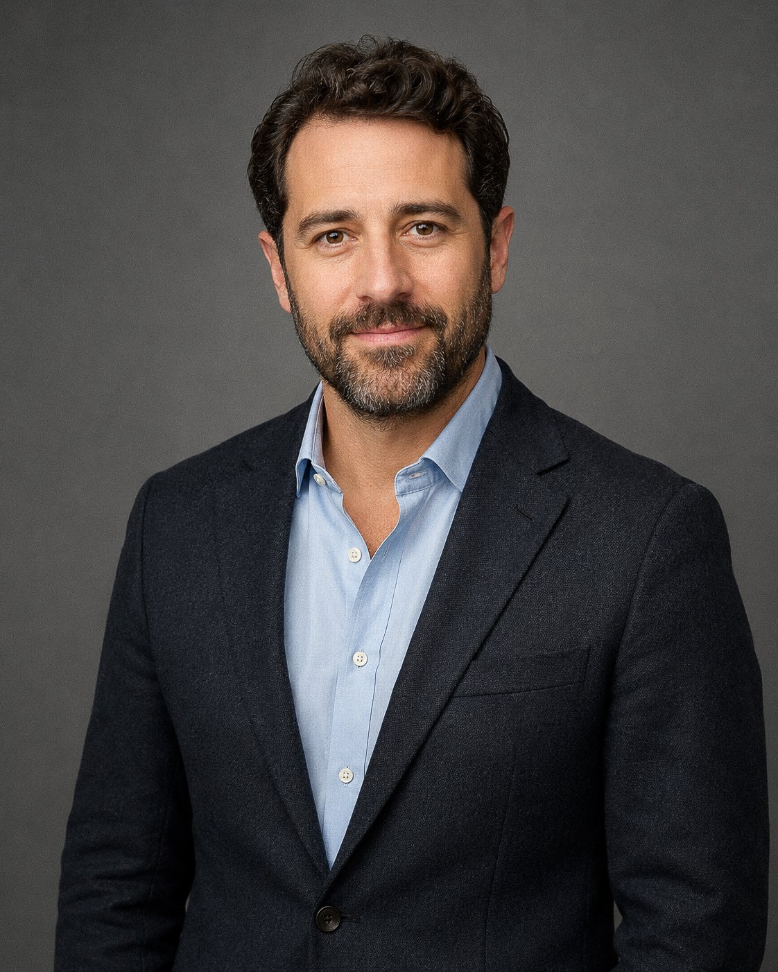  Man wearing a dark suit photographed against a neutral background 