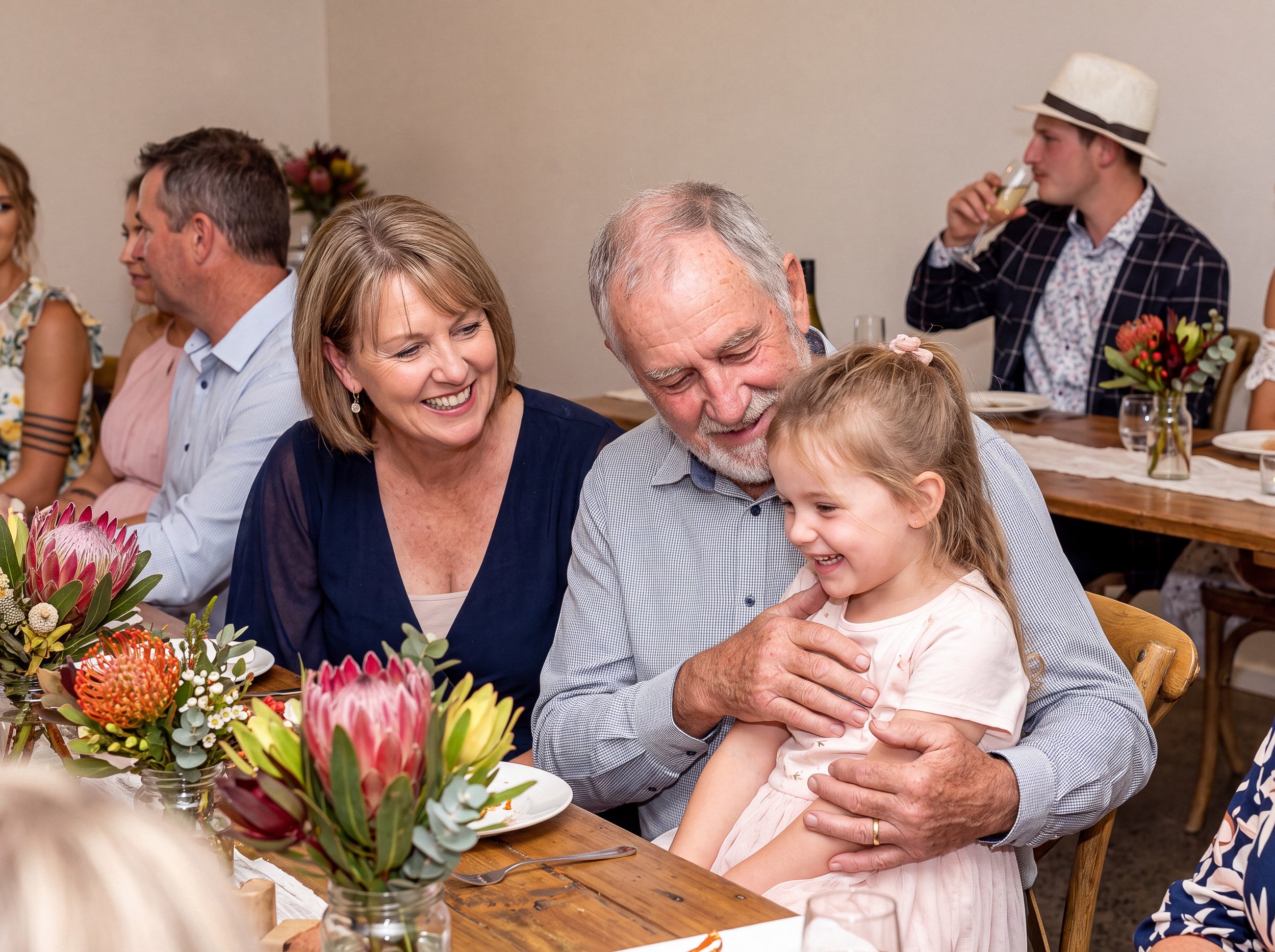 Grandparents sharing a joyful moment with a young child during the reception.