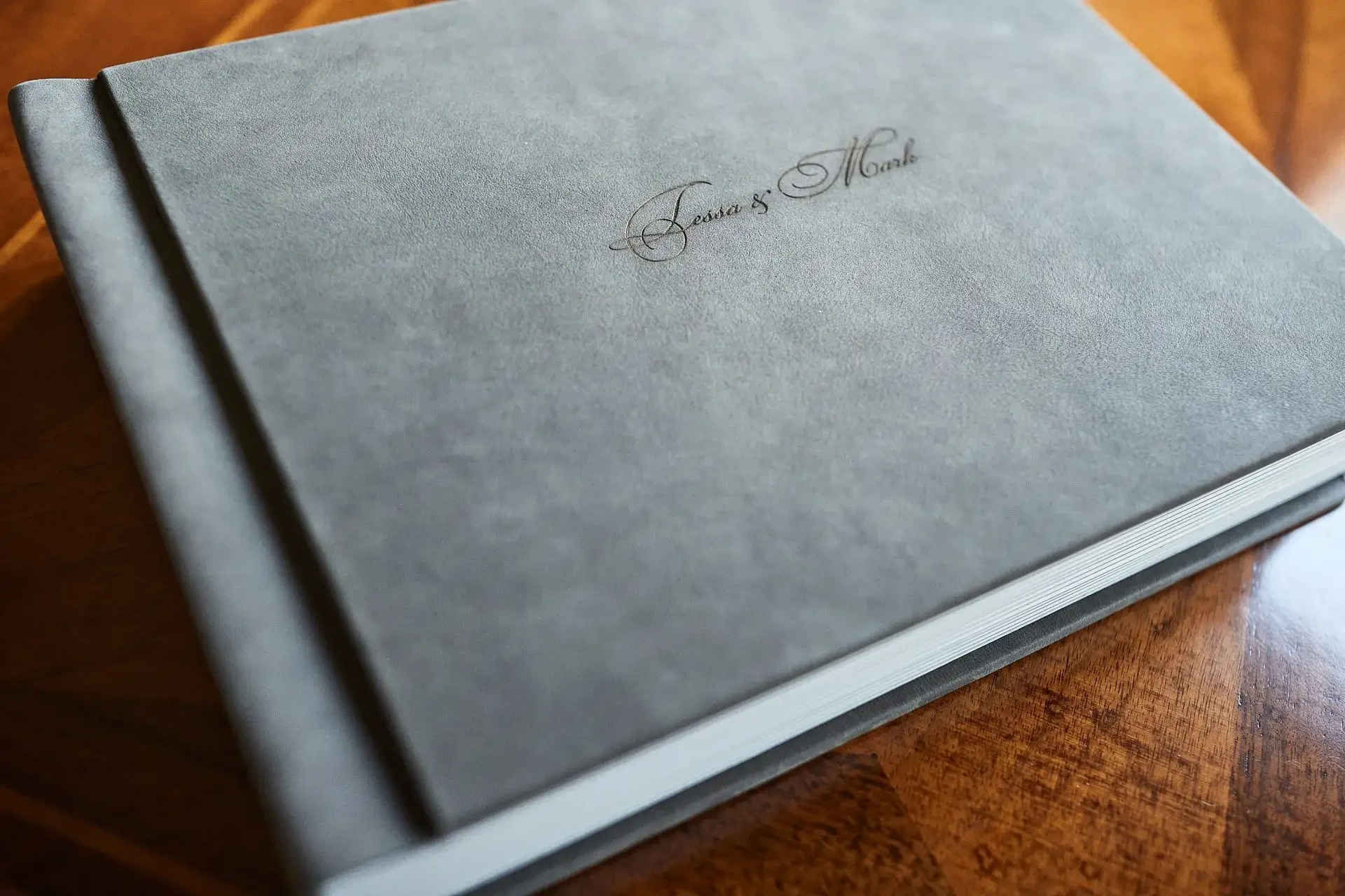 Custom wedding photo album displayed on a wooden table, showing a finished printed keepsake.