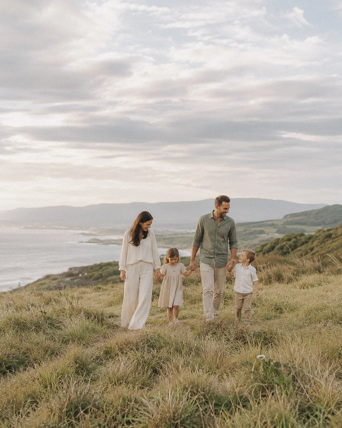 Family walking together through a coastal hillside landscape.