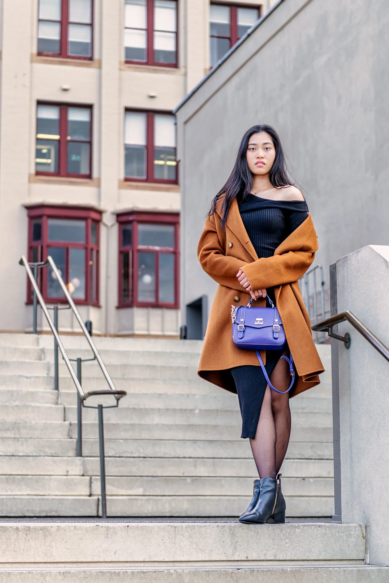 Woman posing on outdoor city steps during an urban lifestyle fashion portrait session.
