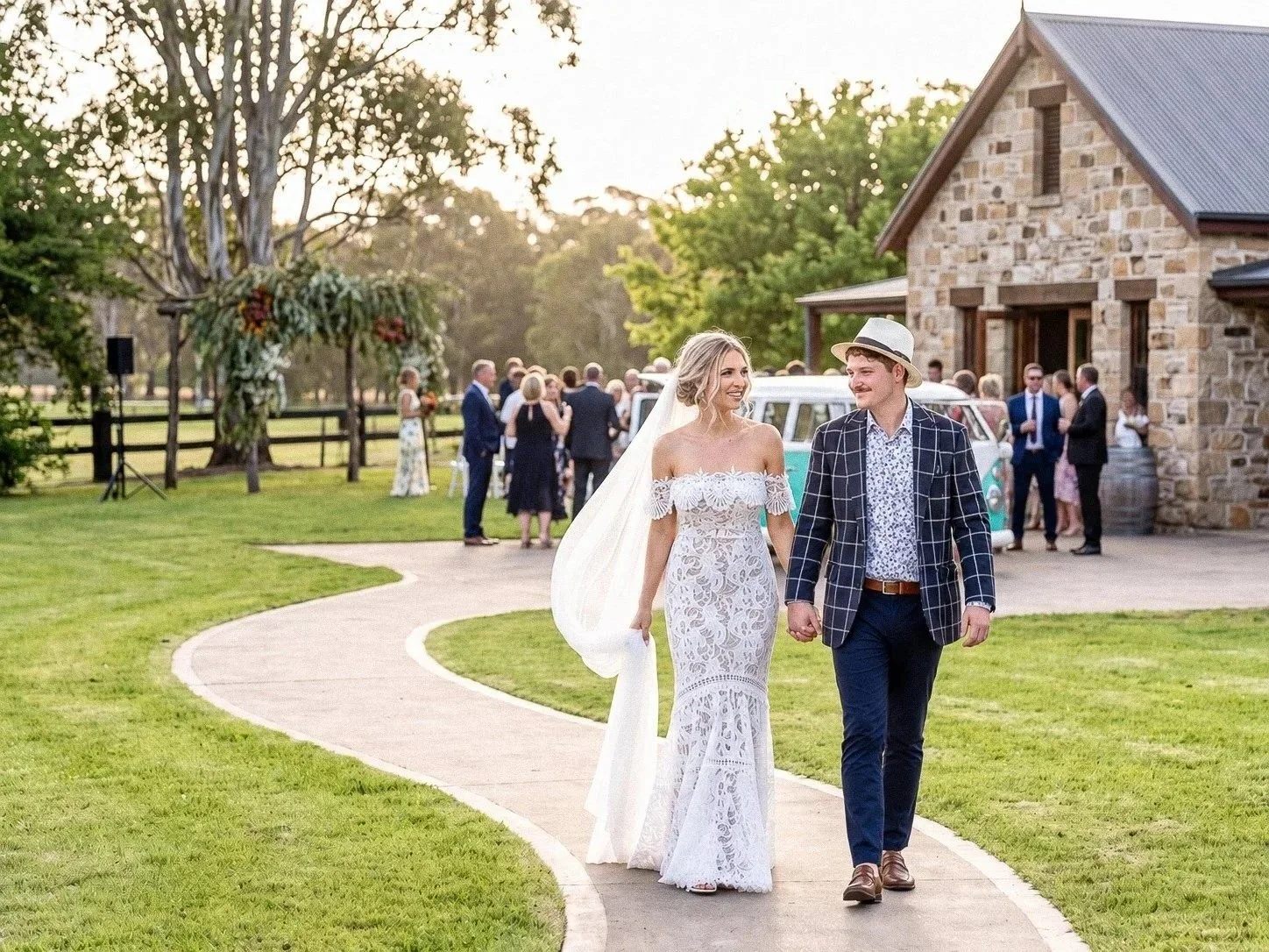 Newly married couple walking from an outdoor ceremony with their wedding party
