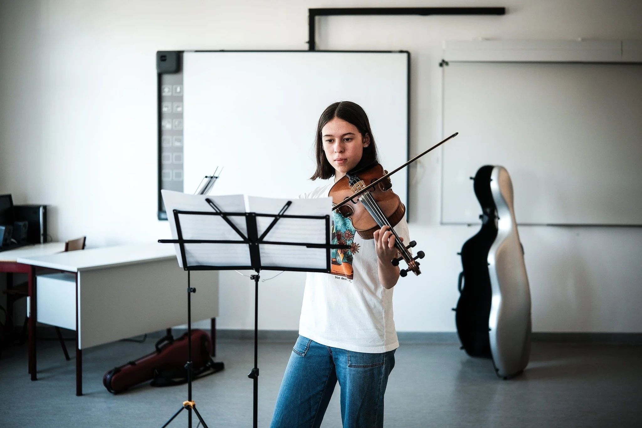 Garota tocando violino em sala de aula
