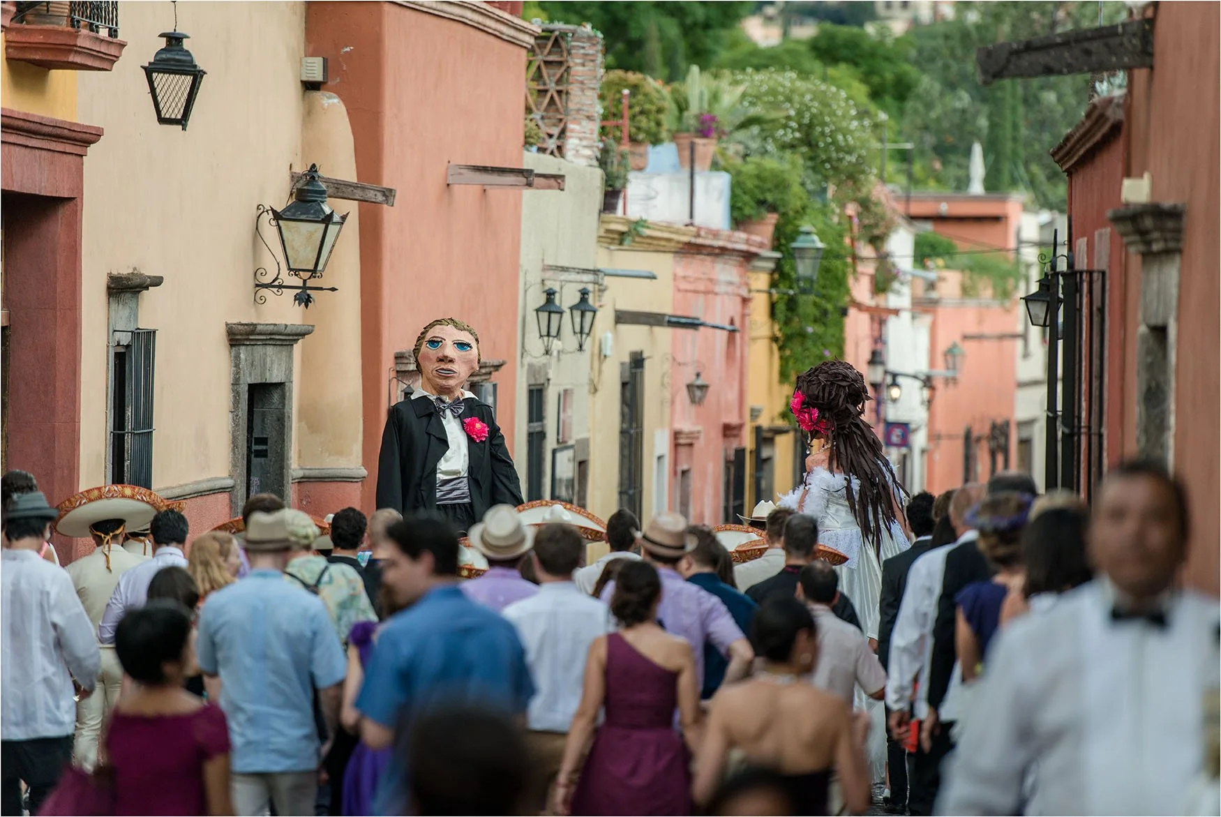 Fotografía de la calle de Aldama en San Miguel de Allende durante la celebración de una boda tradicional con mojiganga