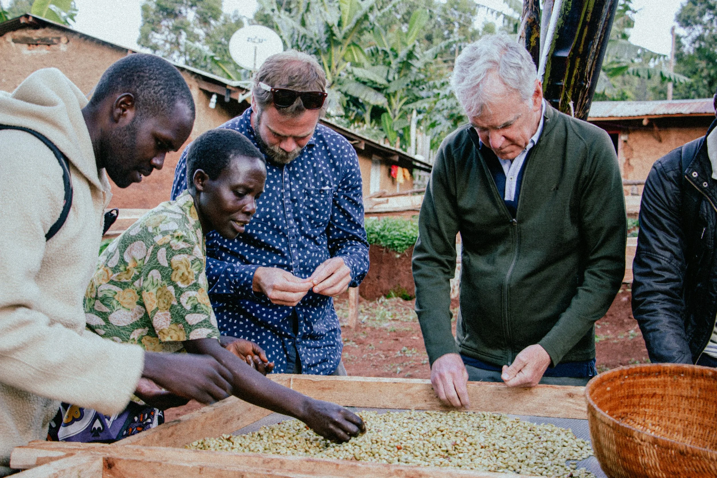 Daniel and Randy at coffee sorting table with others Uganda.jpg (Copy)