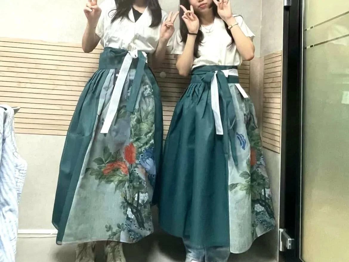 Trying on our hanbok uniform for the first time. Hanbok is a Korean traditional dress, and we made sure the dress included our theme colors: 청현색, 취람색, 비색. These are also Korean traditional colors.