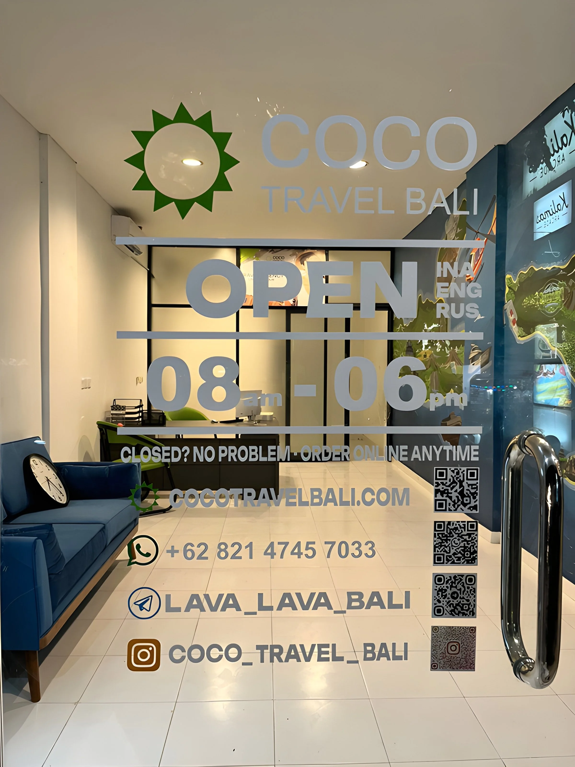 Glass door of travel agency named Coco Travel Bali with business hours, contact information, and social media info, including website, WhatsApp, Telegram, and Instagram logos.