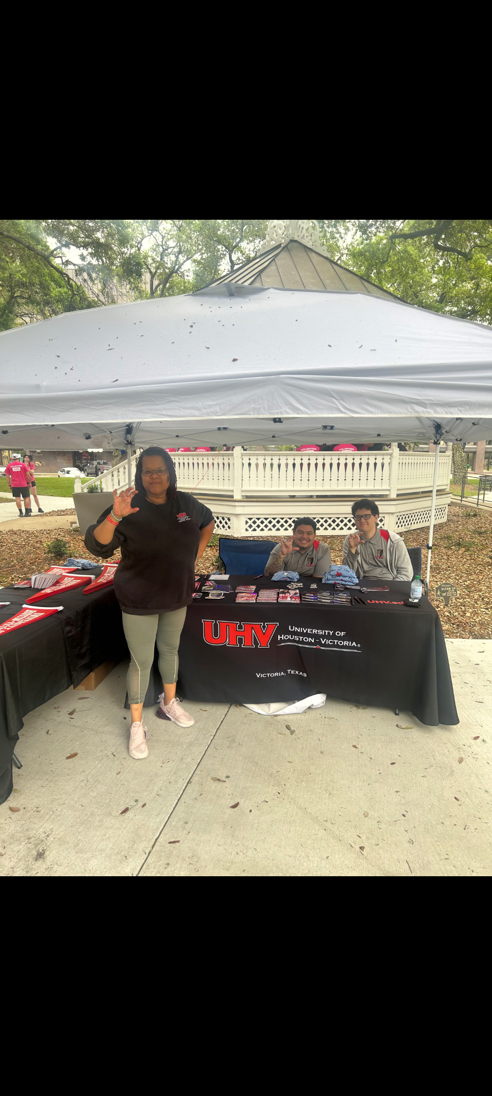 People at a University of Houston-Victoria information booth under a white canopy.