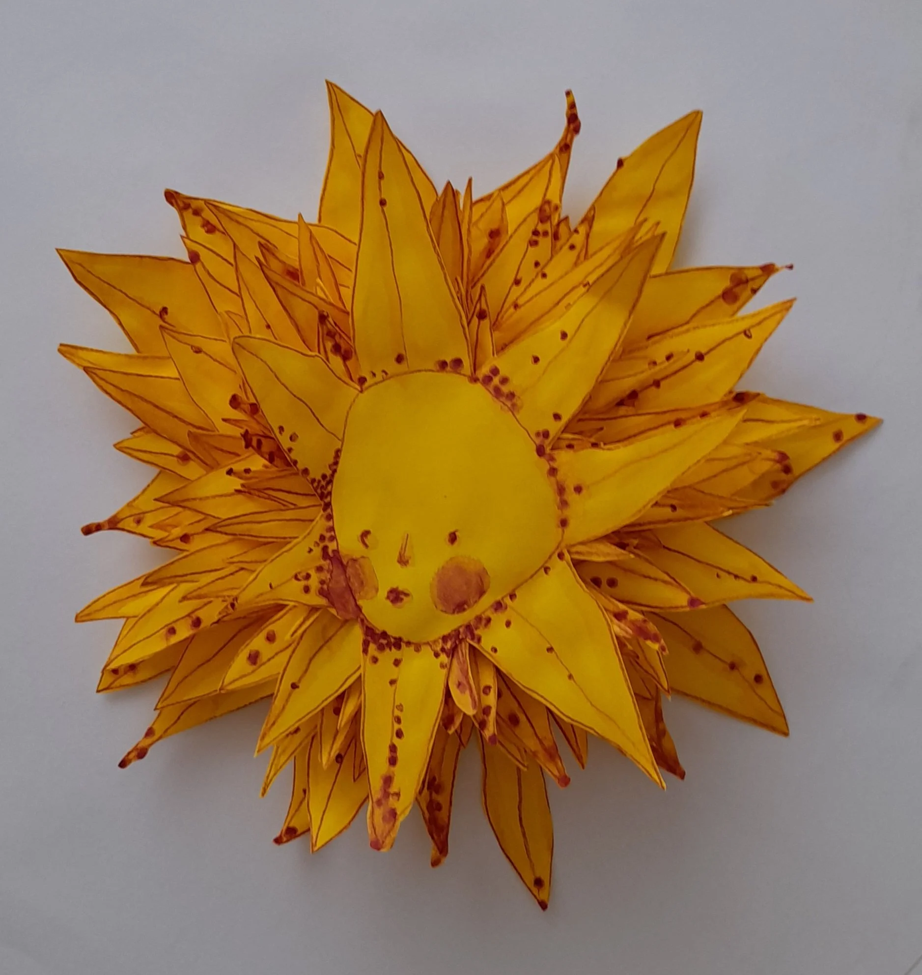 A handmade paper craft lion with a yellow face and orange mane on a white background.