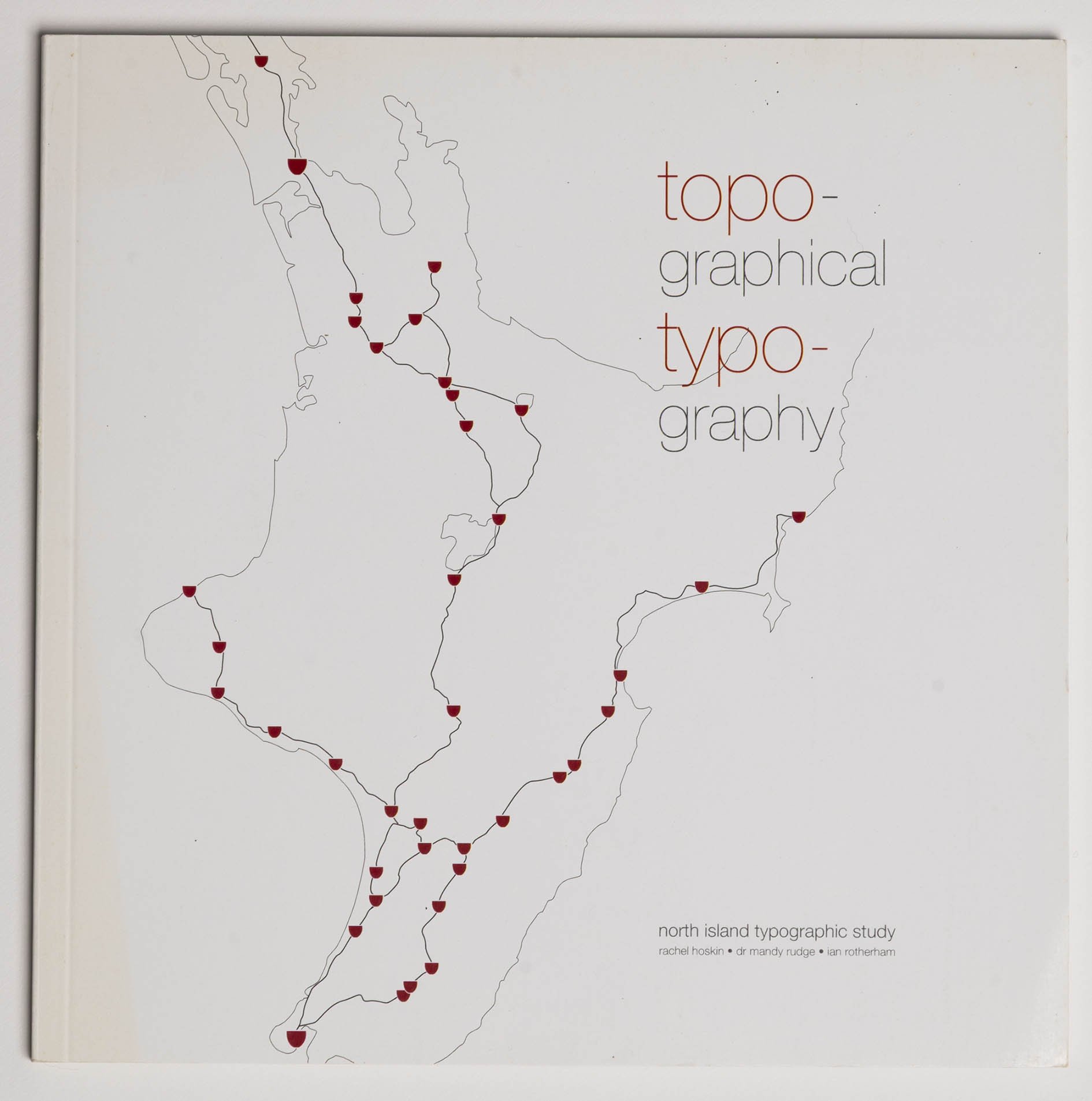 Cover of a book titled 'topo-graphical typo-graphy' with a map outline and red markers on it. The text also includes 'north island typographic study' by Rachel Hoskin, Dr. Mandy Rudge, and Ian Rotherham.