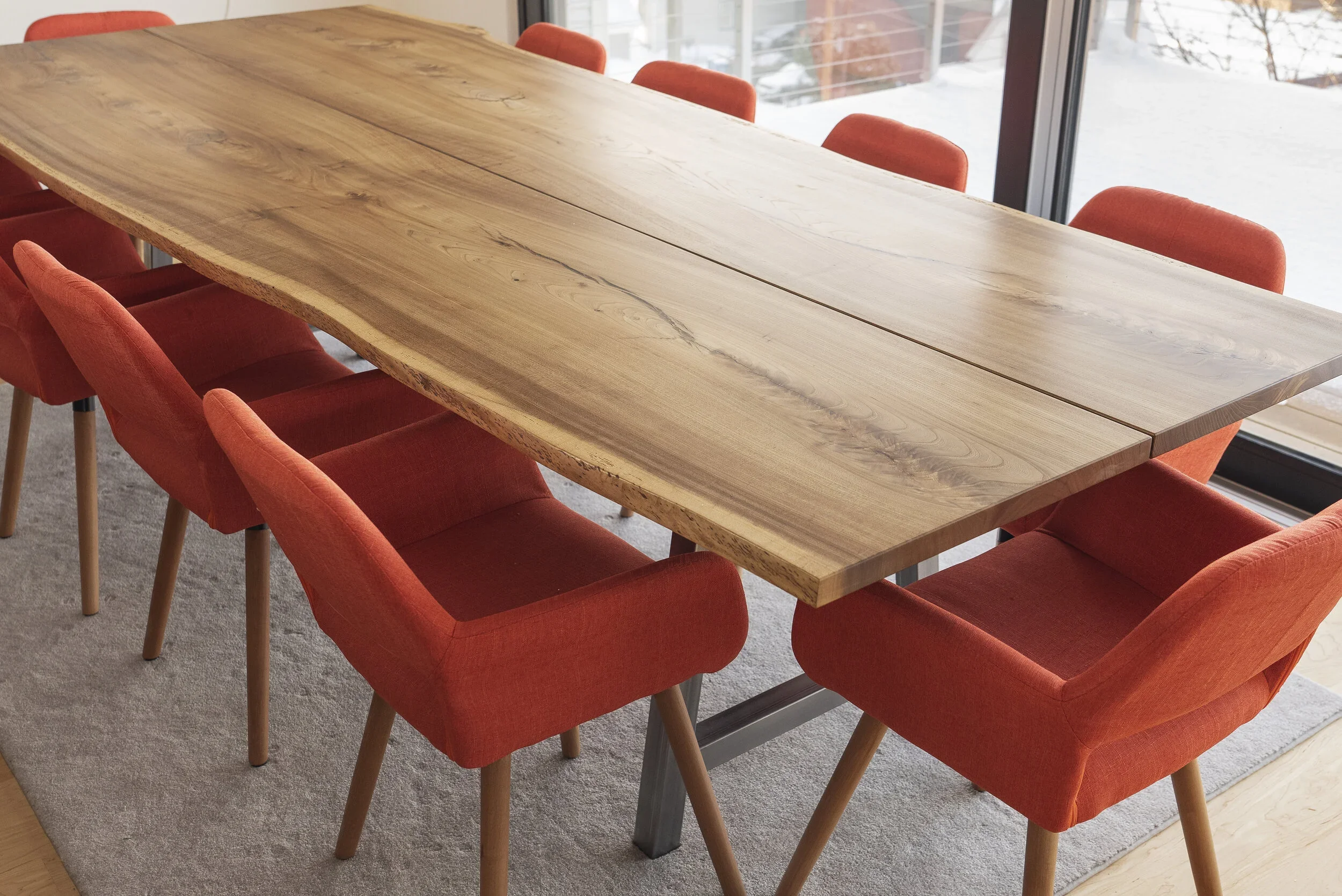 Live edge hardwood dining table with orange chairs