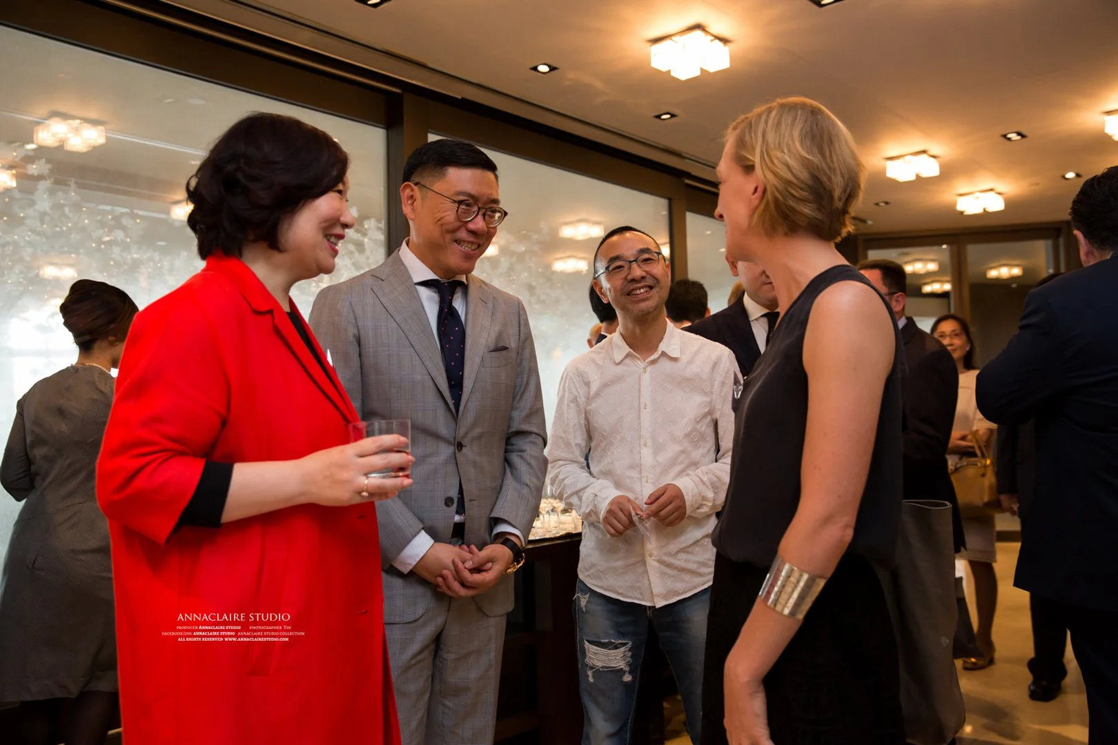Group of well-dressed people socializing at an indoor event