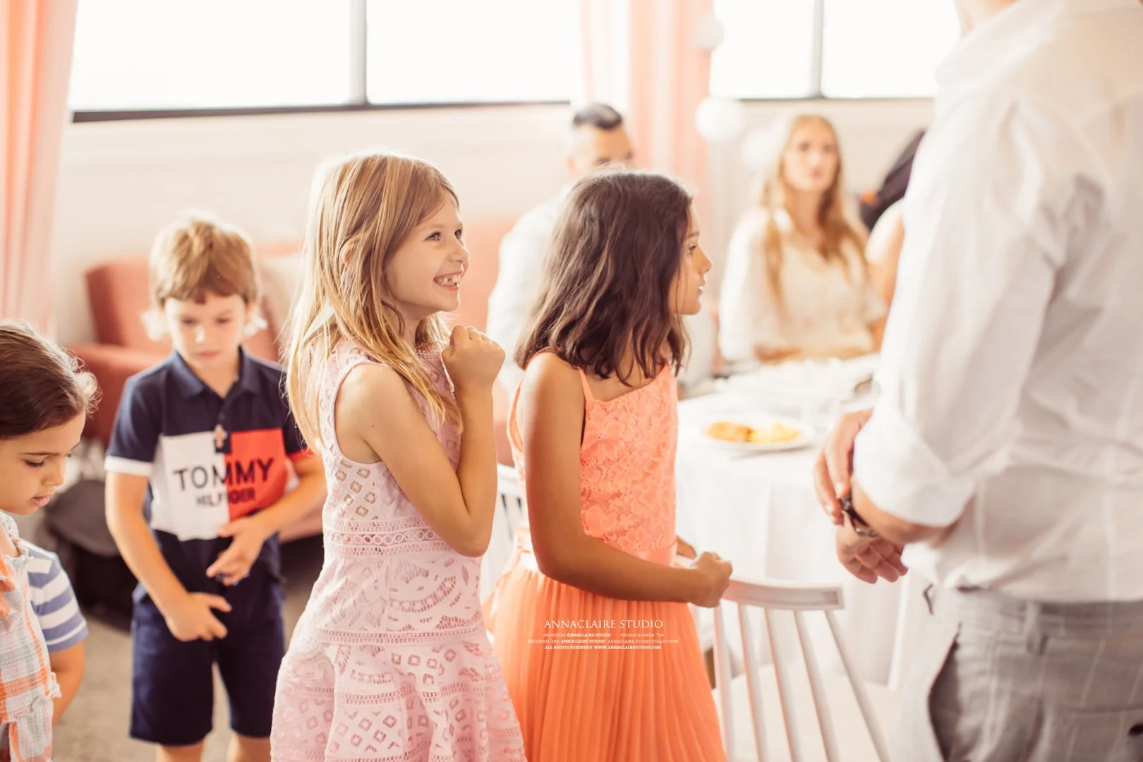 Children at a birthday party lining up to receive a gift from an adult.