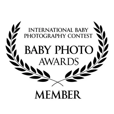 International Baby Photography Contest badge with laurel leaves, text reading 'Baby Photo Awards' and 'Member'.